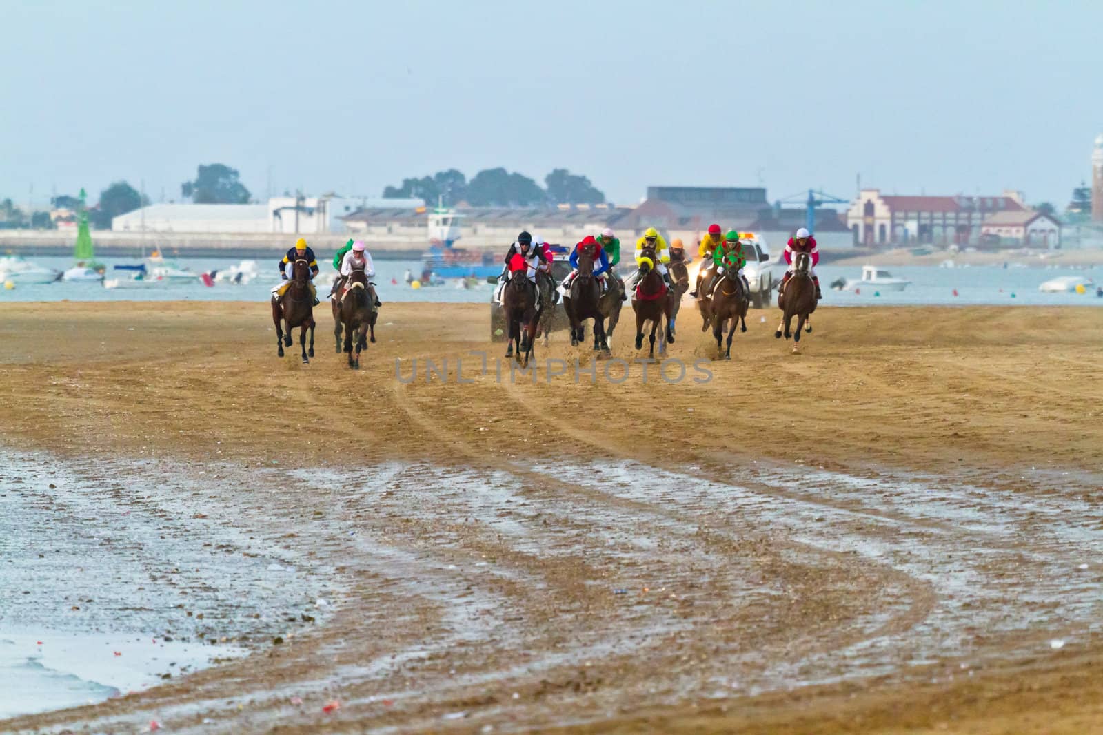 SANLUCAR DE BARRAMEDA, CADIZ, SPAIN - AUGUST 10: Unidentified riders race horses on Sanlucar de Barrameda beach on August 10, 2011 in Sanlucar de Barrameda, Cadiz, Spain.