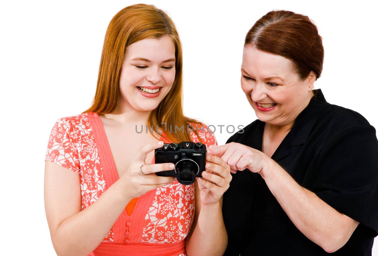 Mature and young women holding a camera isolated over white