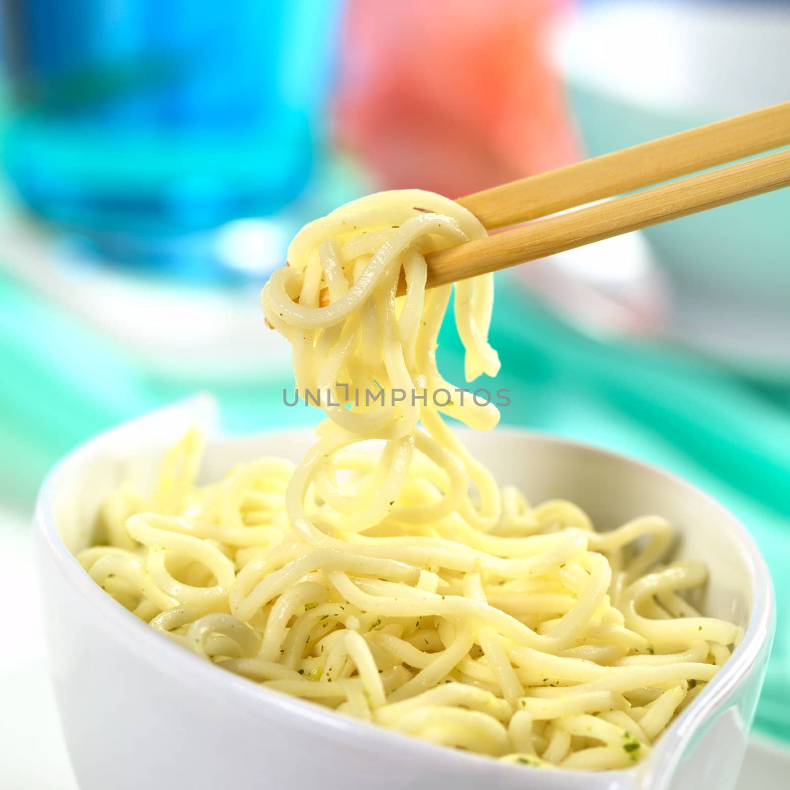 Vegetarian Asian noodle soup and some noodles on chopsticks (Selective Focus, Focus on the front of the noodles on the chopsticks)
