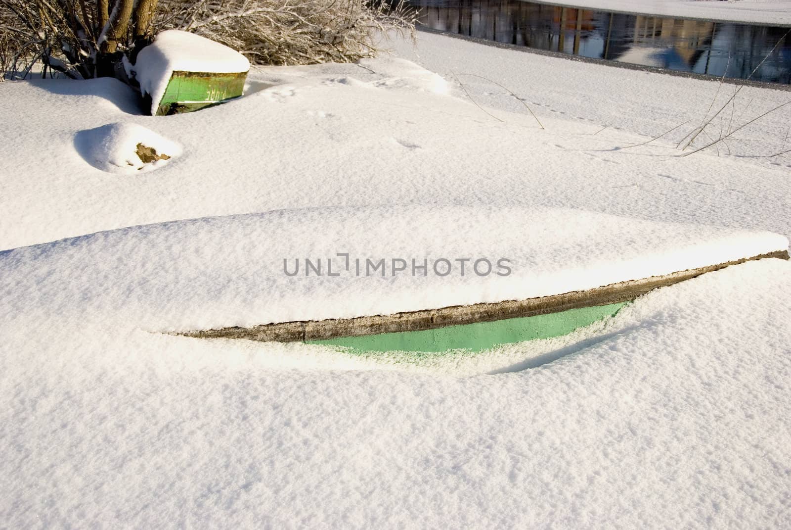 Snow covered boats fragments protruding from snow. by sauletas