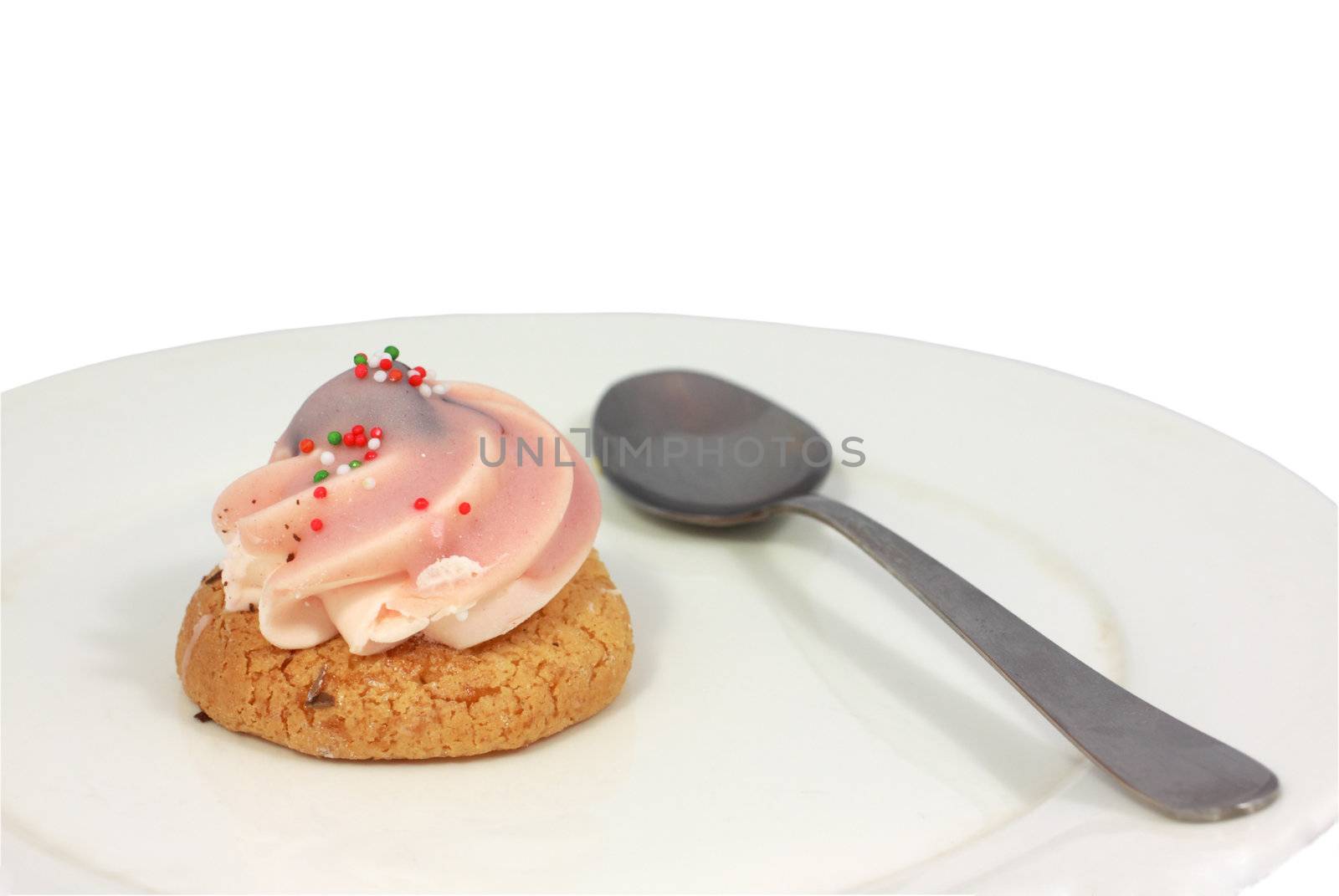 dessert with rose cream and spoon on the white plate