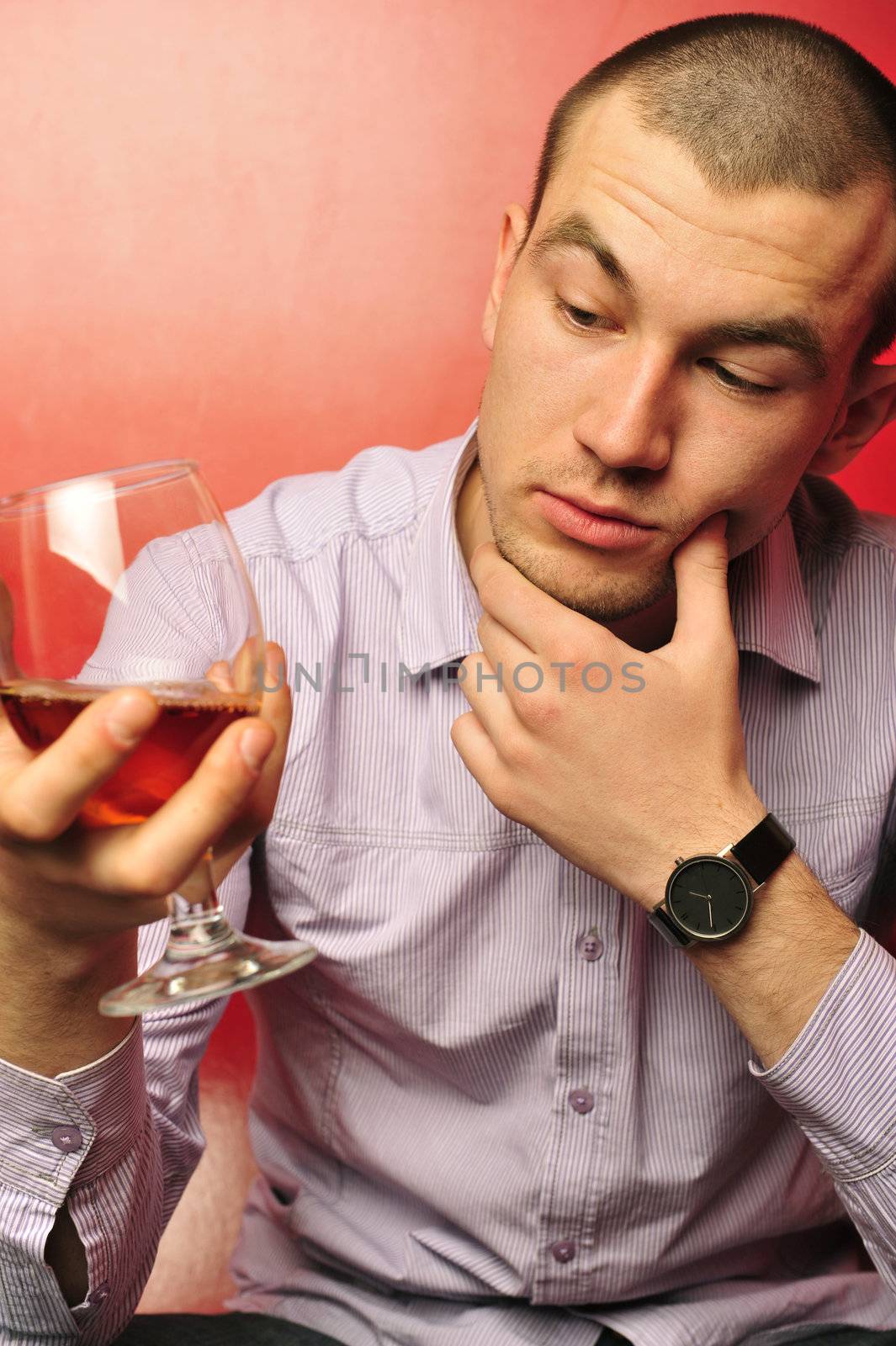 young with a glass of wine  isolated on red