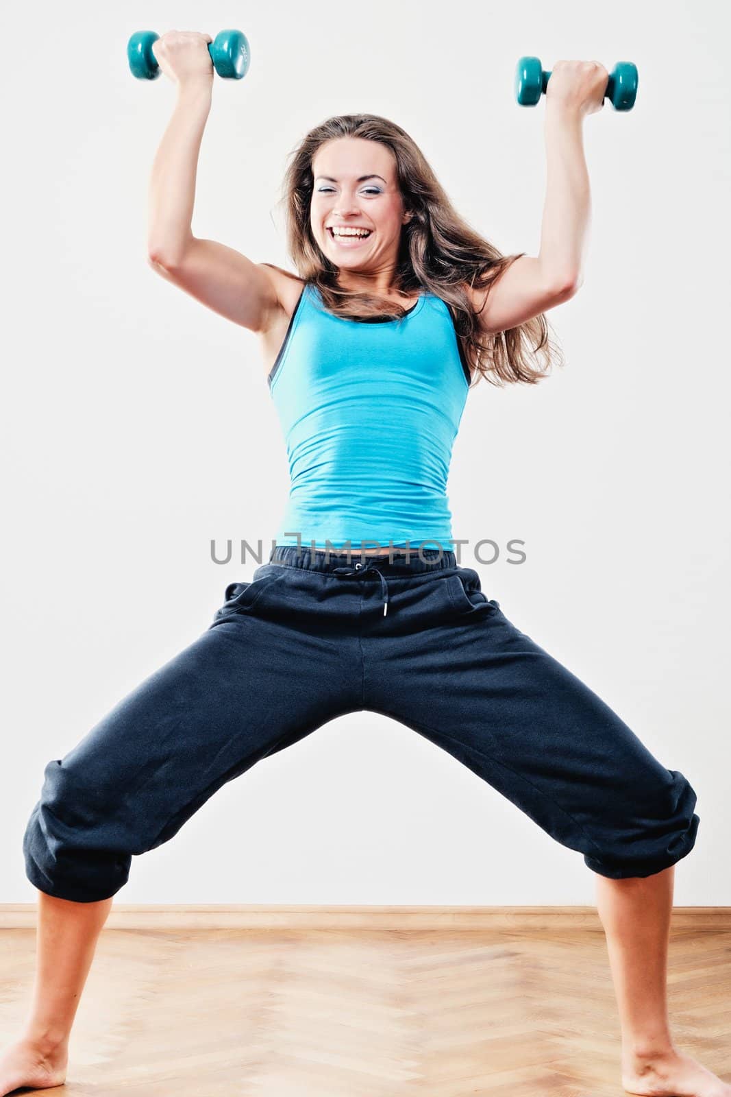 Young woman to training of athletic exercise with dumbbells