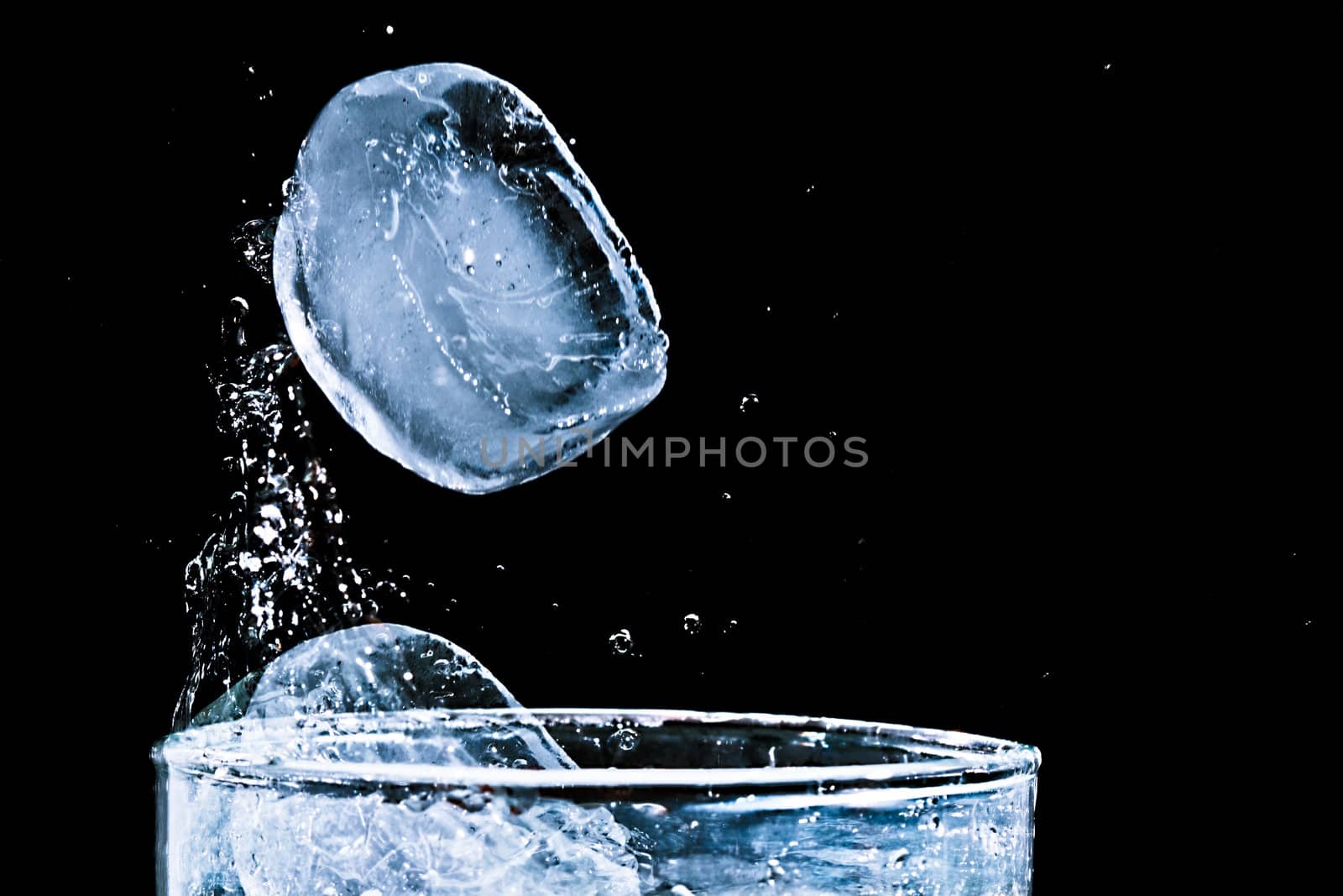 The motion of ice splashing into a glass of water frozen in time