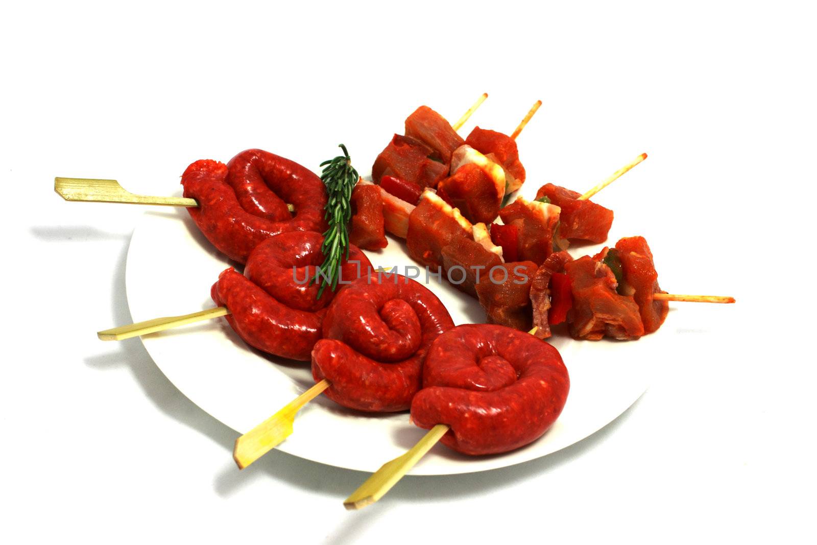 raw shashlik and sausages for barbecue on the white plate