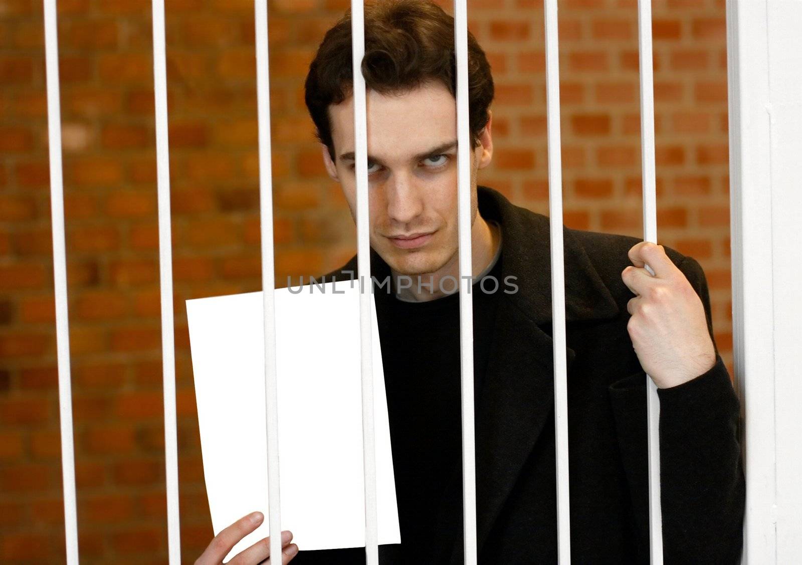 Man locked into a prison cell showing a blank sheet