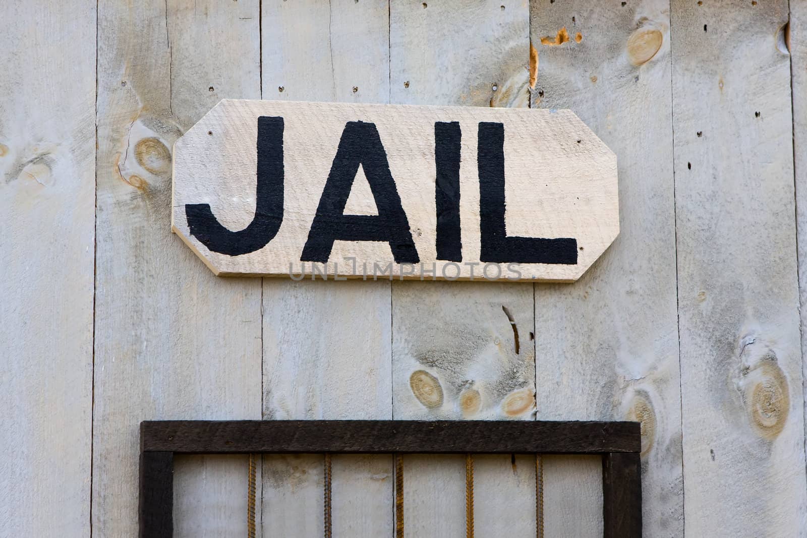 An old-fashioned Western jail sign hanging on a wall.