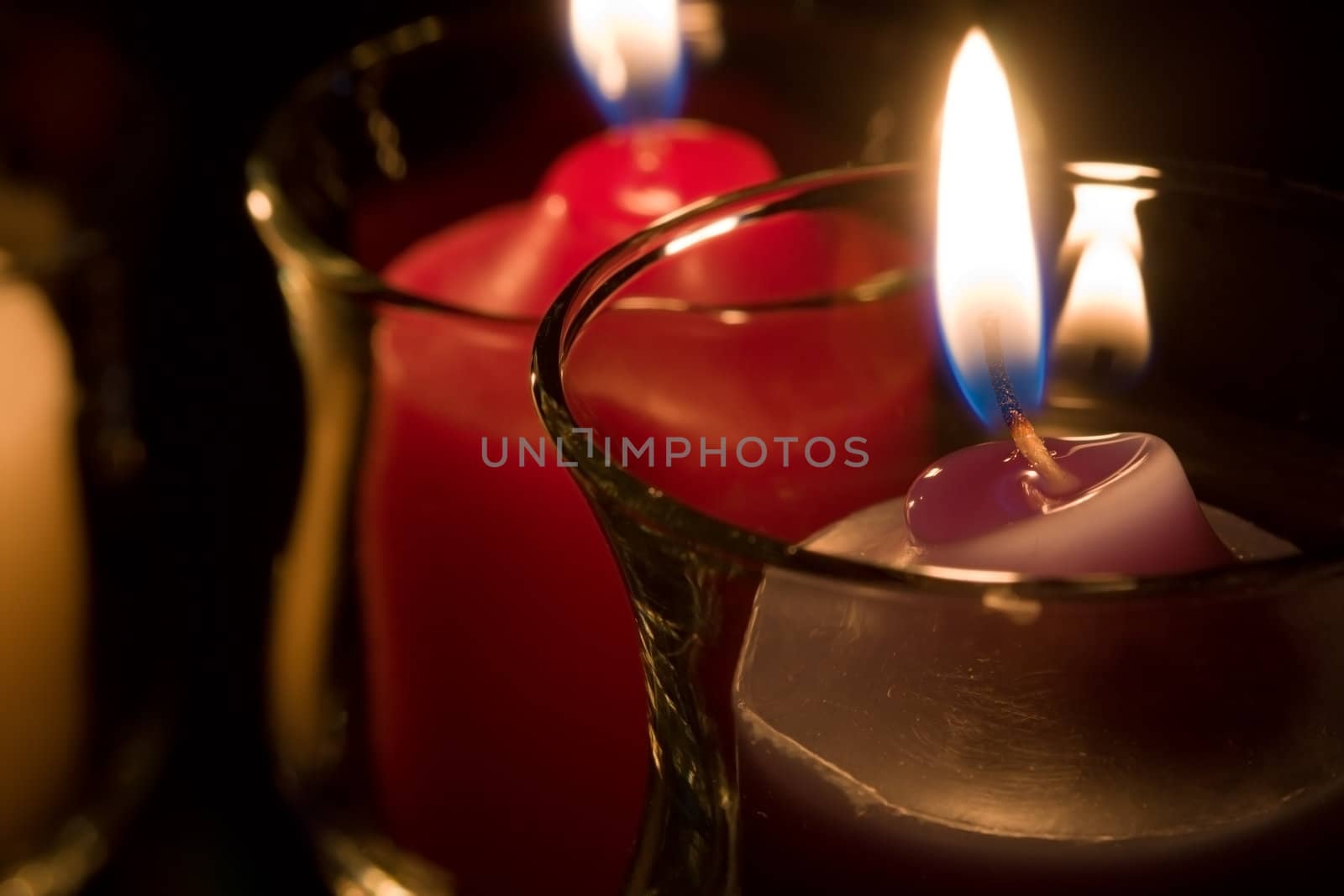 beautiful lit candles in decorative glass holders.