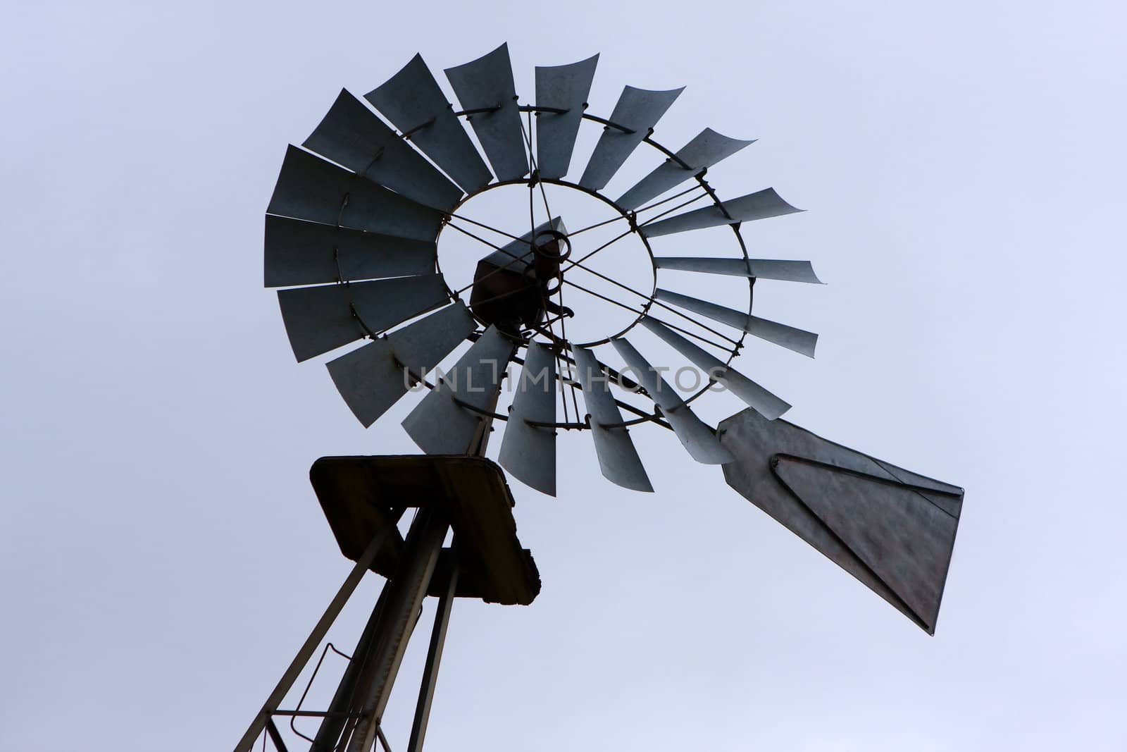 A backlit portrait of an Old Fashioned Farm Windmill.