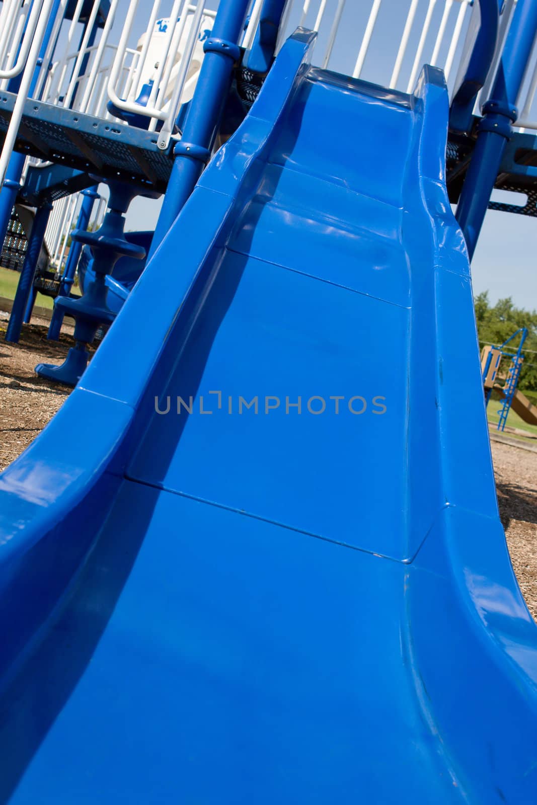 Blue slide attached to a large playground.