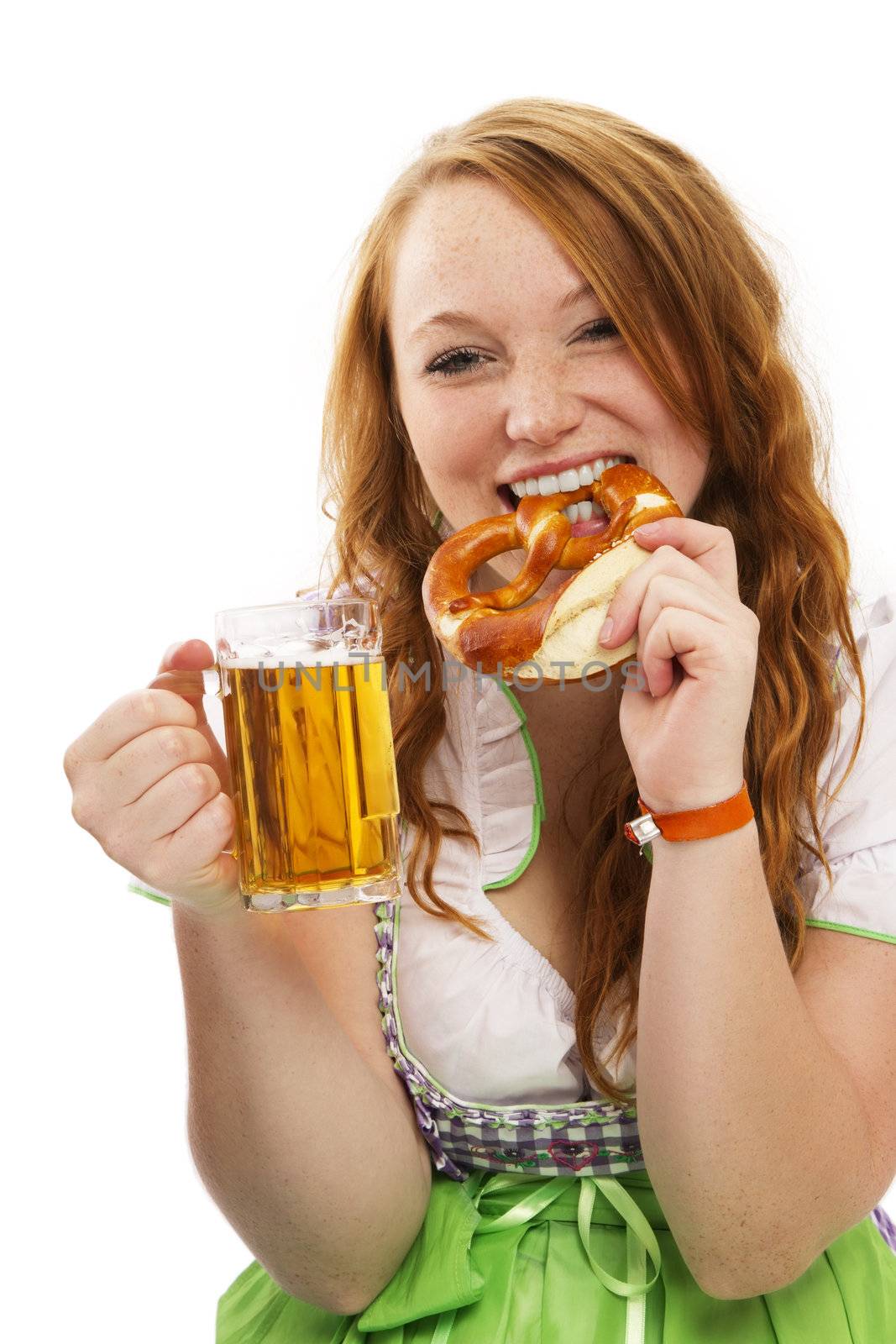 redhead woman in bavarian dress with beer eating pretzel on white background