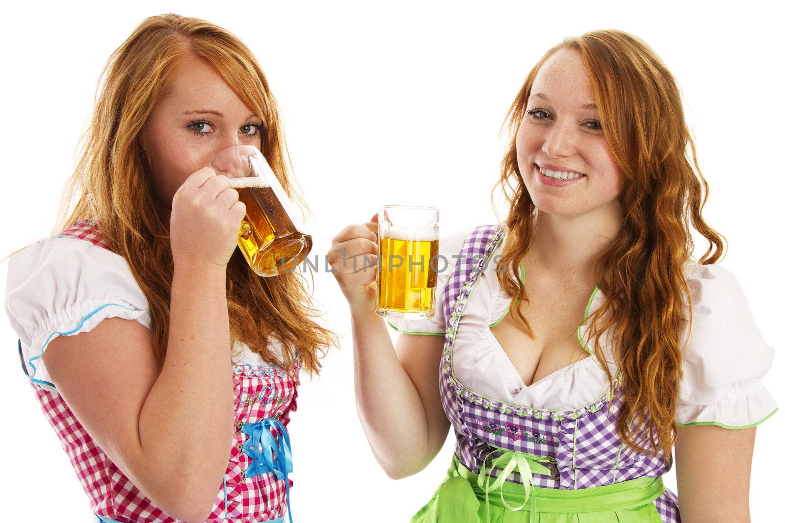 two bavarian girls laughing and drinking beer on white background