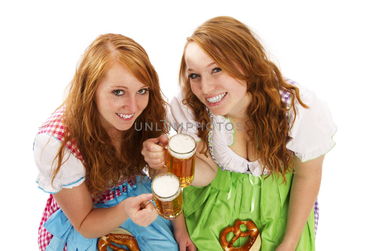 two bavarian girls with beer and pretzels on white background