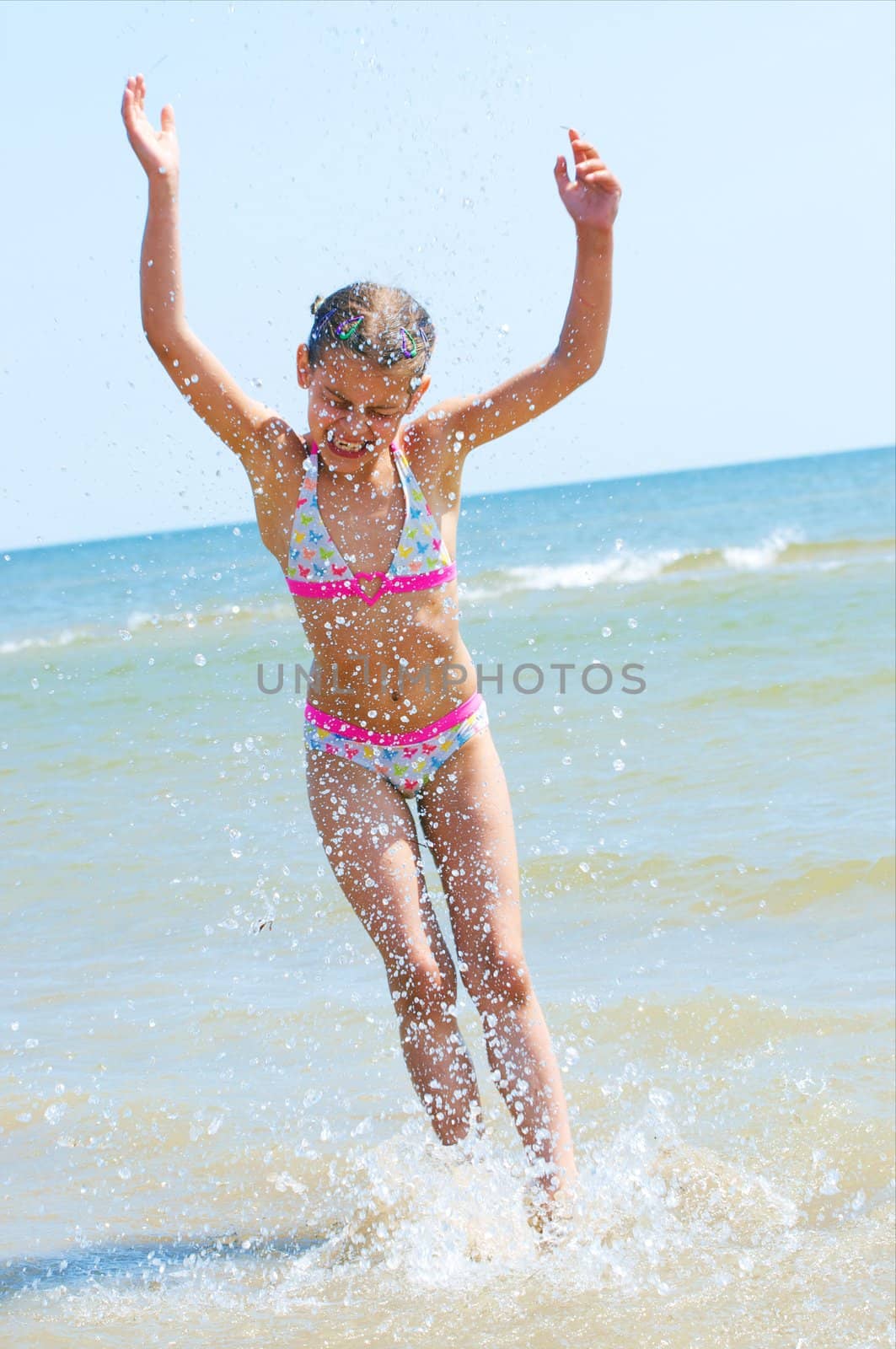 A happy child is running at the beach.