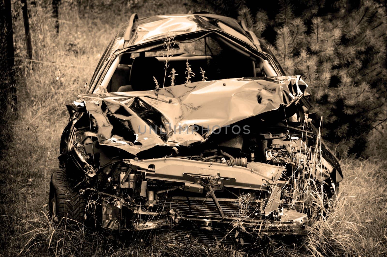 Old damaged rusty car wreck abandoned in the grass