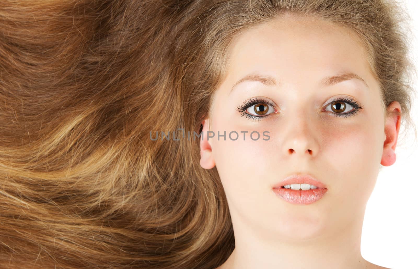 Healthy beautiful long hair closeup in motion created by wind. Isolated on white