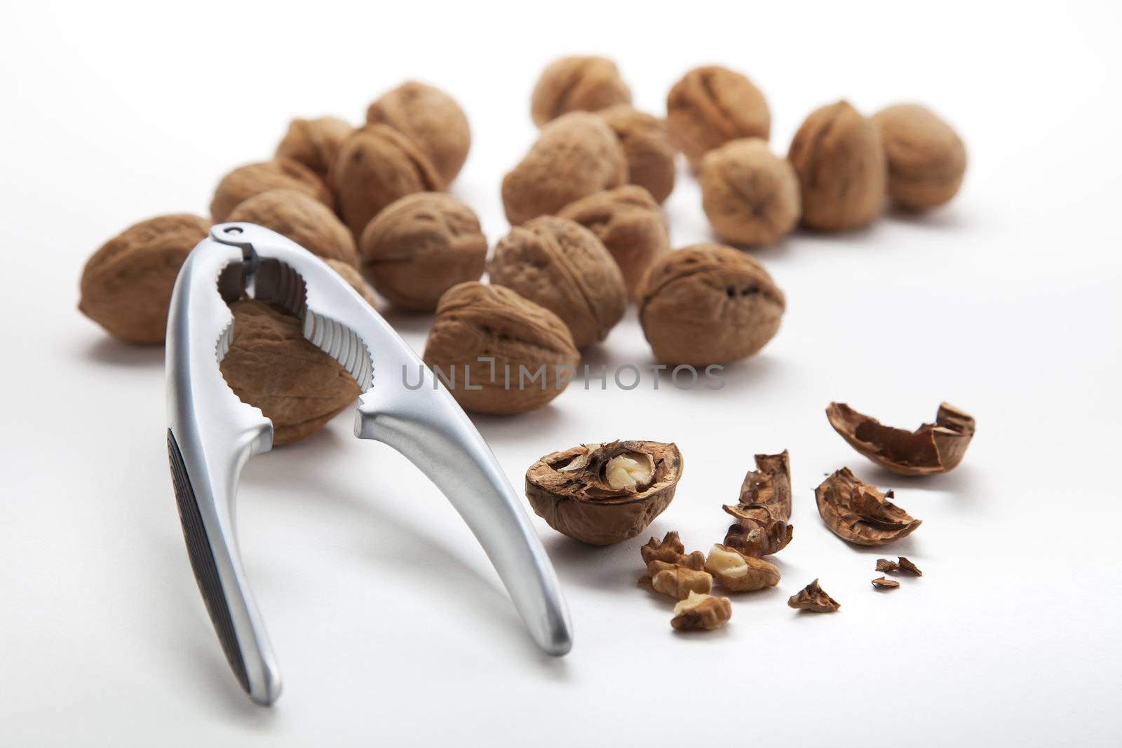 Walnuts both whole and cracked with nutcracker.