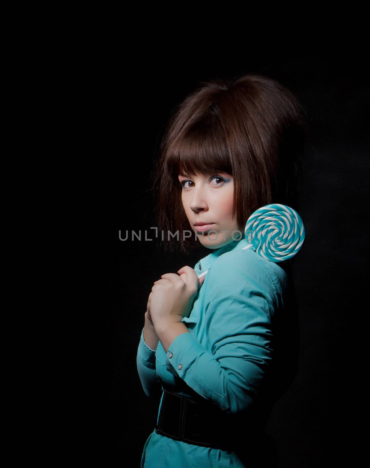 young woman with lolipop, black background