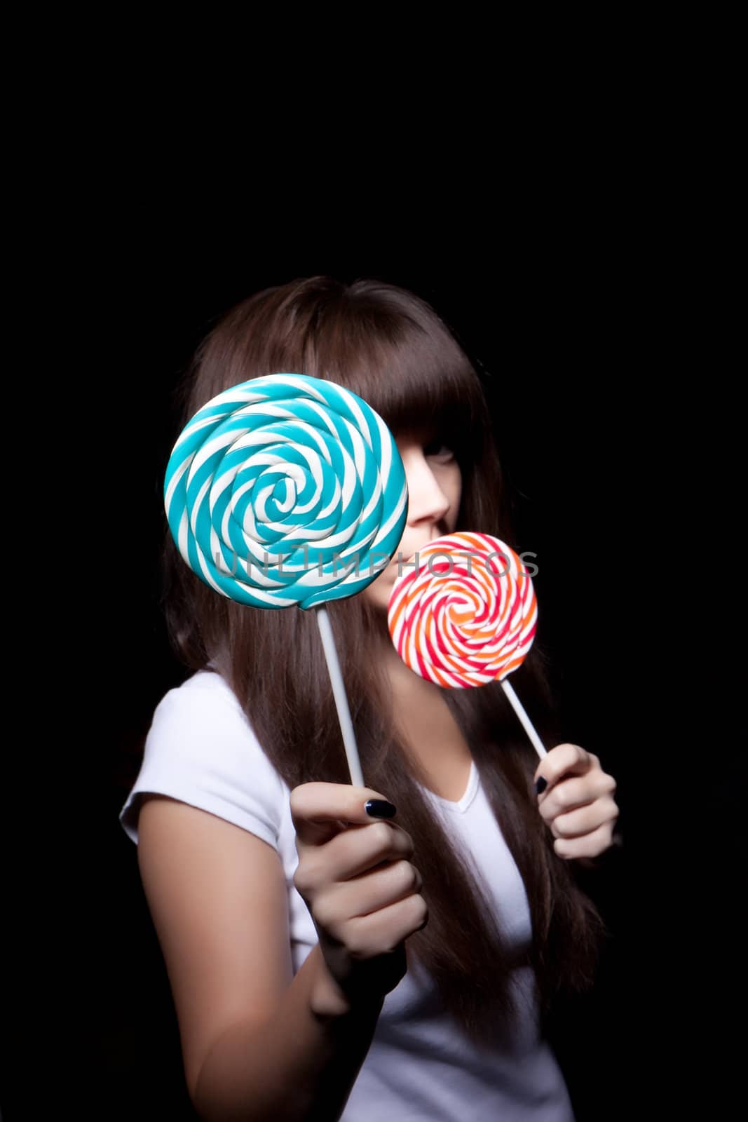 
young woman with lolipop, black background