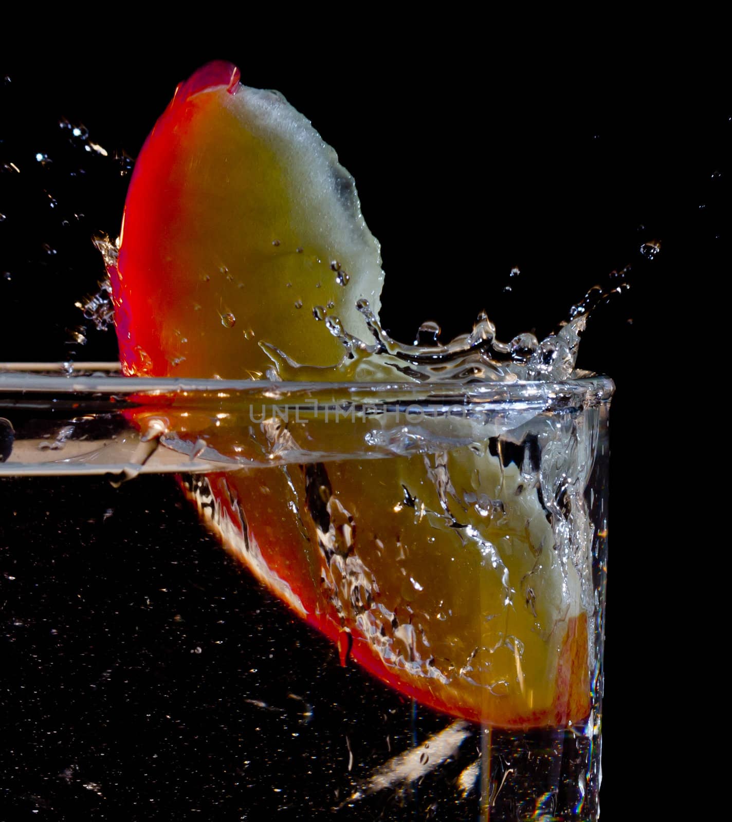 The motion of a slice of apple splashing into a glass of water