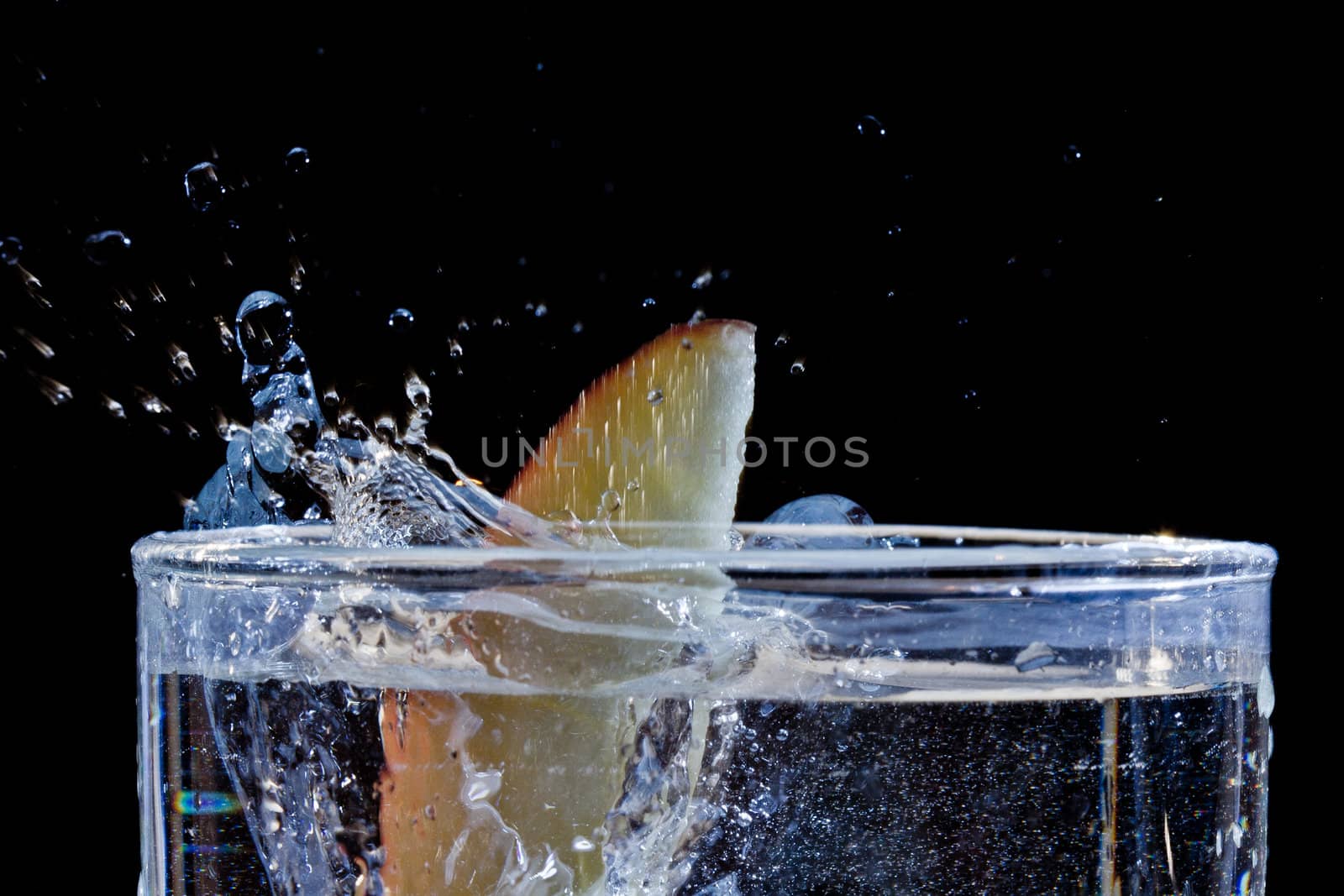 The motion of a slice of apple splashing into a glass of water