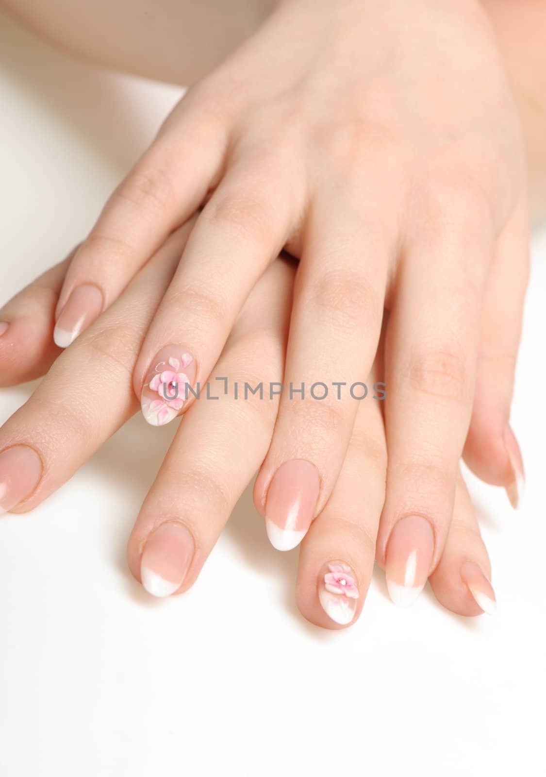 Manicure isolated on white. Well-groomed female hands with a decorative element - a flower