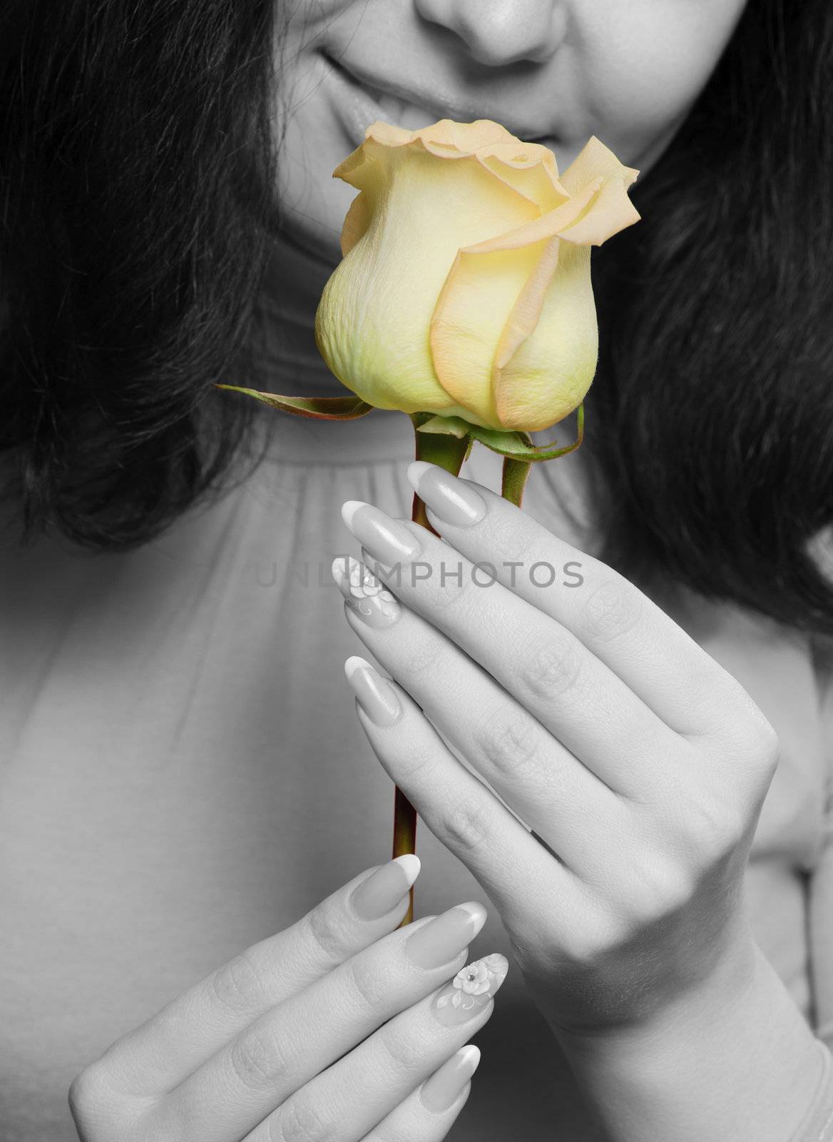 The woman with a yellow rose close up. The monochrome image of the woman and a color rose
