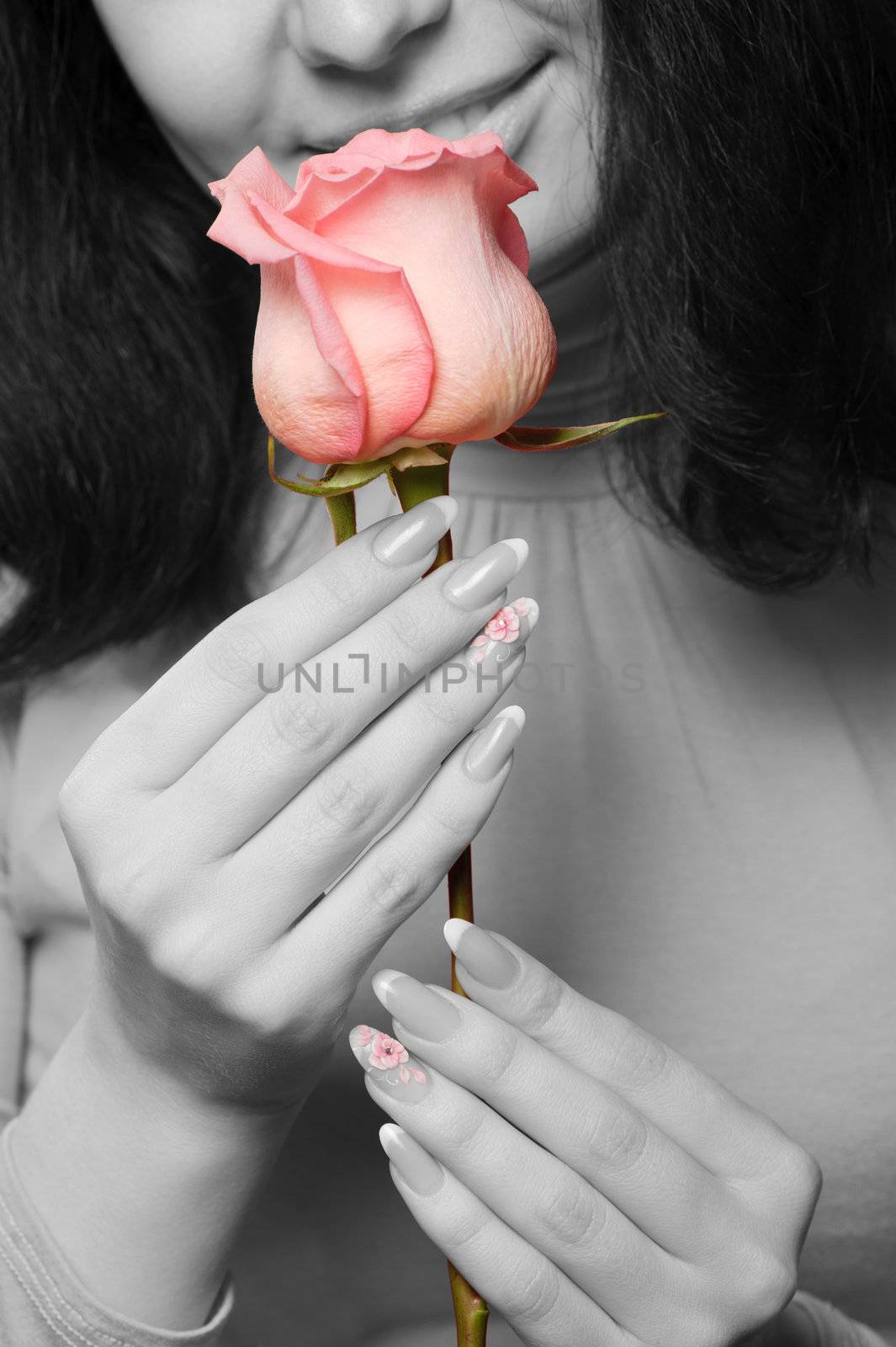 The woman with a rose close up. The monochrome image of the woman and a color rose