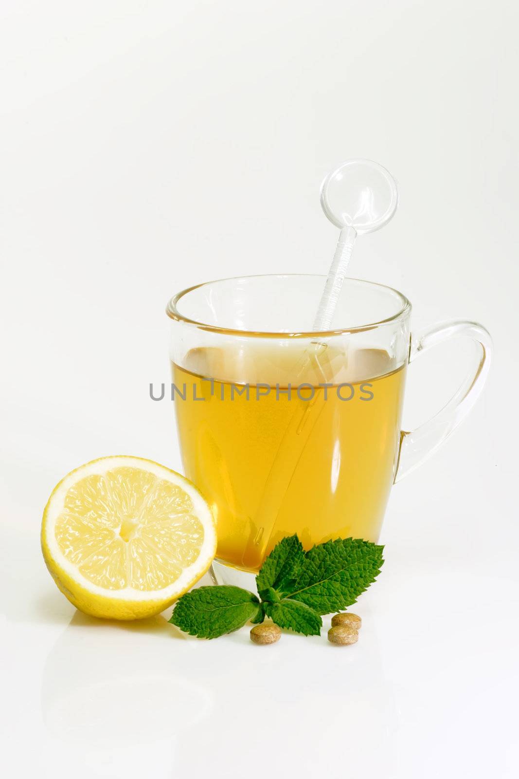 Glass of hot tea with peppermint on bright background