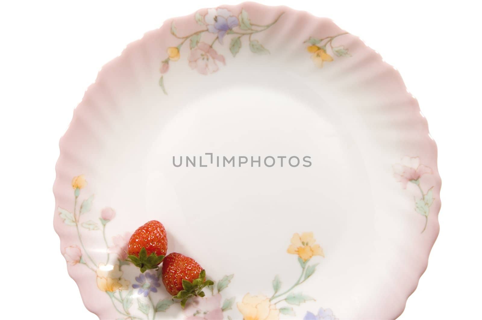 Two juicy strawberries on a tea saucer