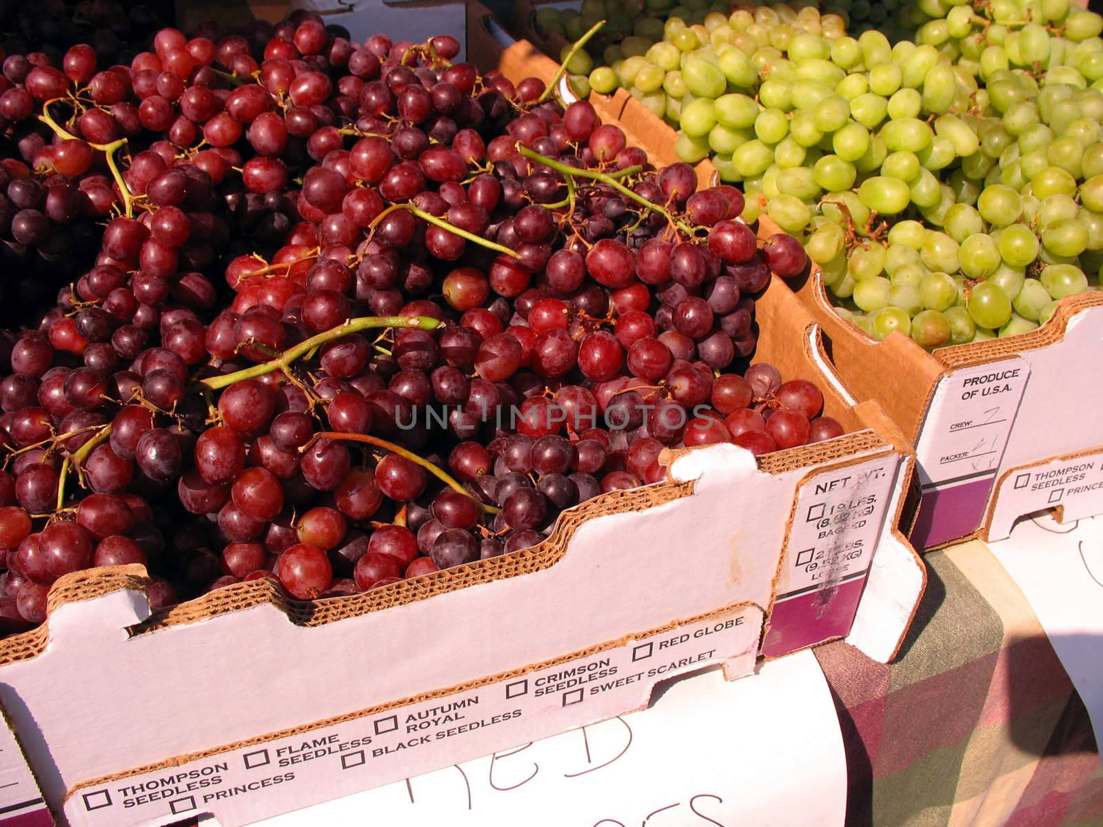 Some red and green grapes for sale at the farmers market.