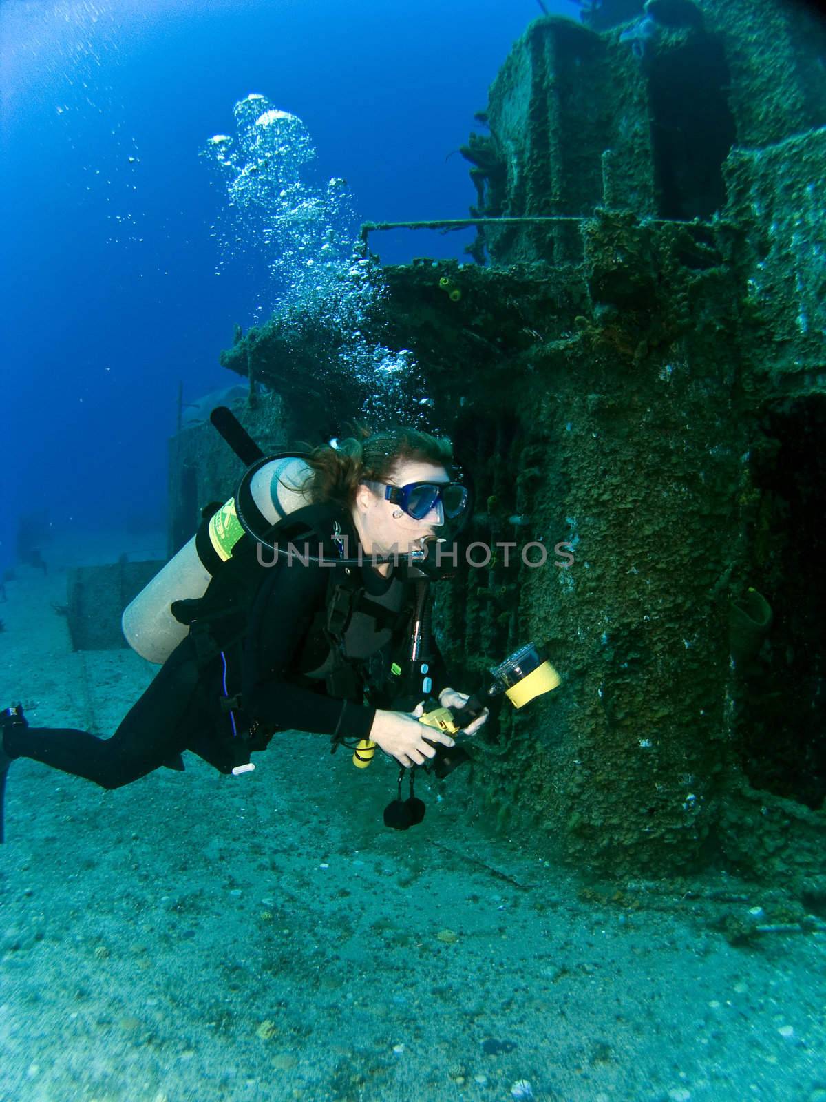 Female Underwater Photographer swimming off the side of a sunken Destroyer