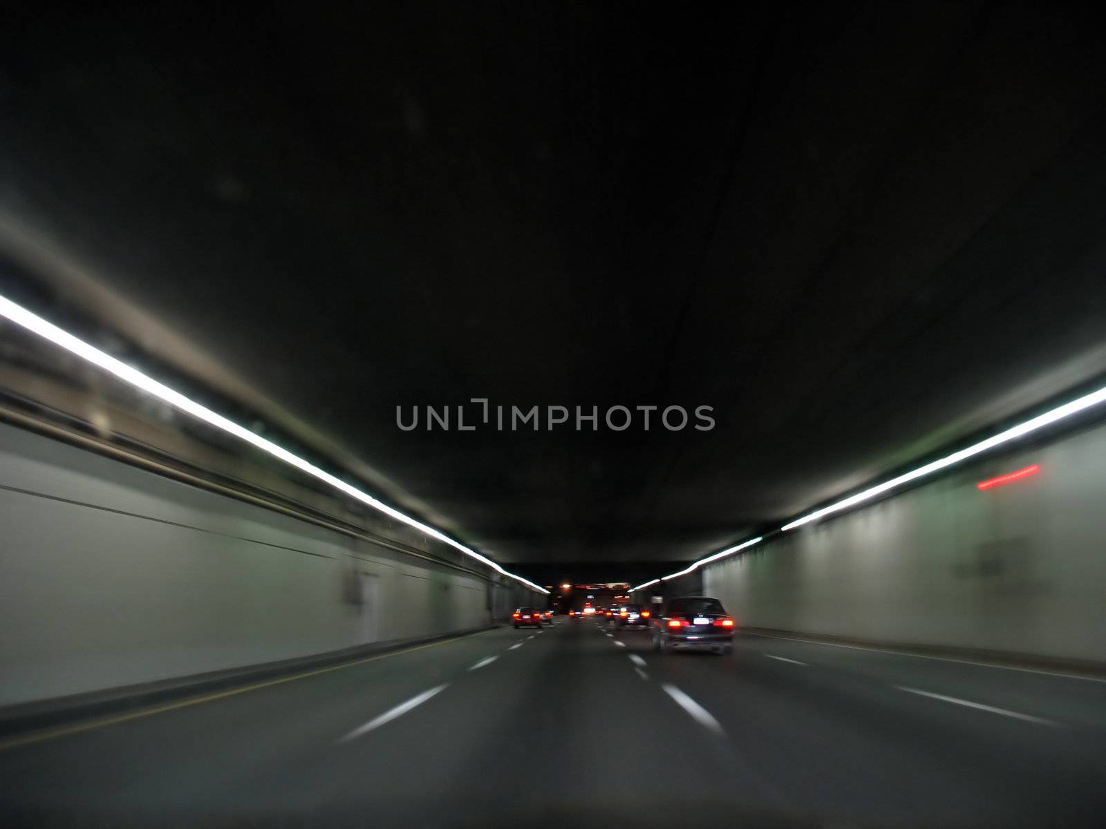 Speeding down the highway through a tunnel at night time.