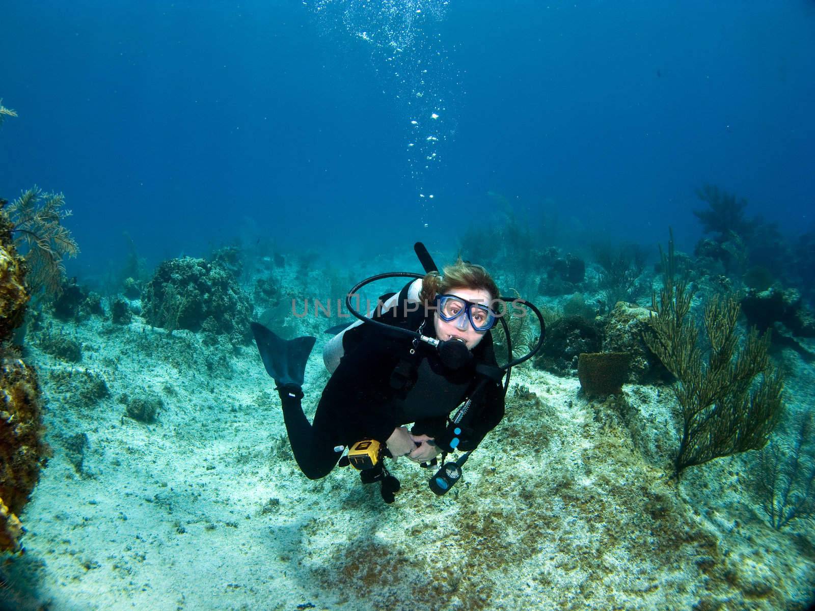 Female Scuba Diver swimming while looking at the Camera