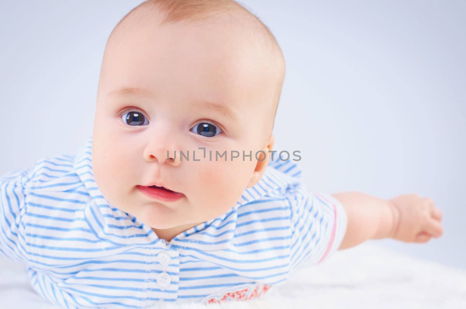 Clouse-up portrait pretty little girl in blue. In studio