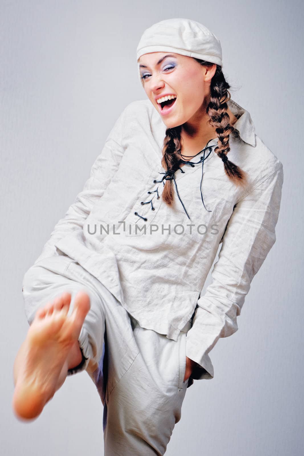 Joyful young woman in white suit. Isolated on white background