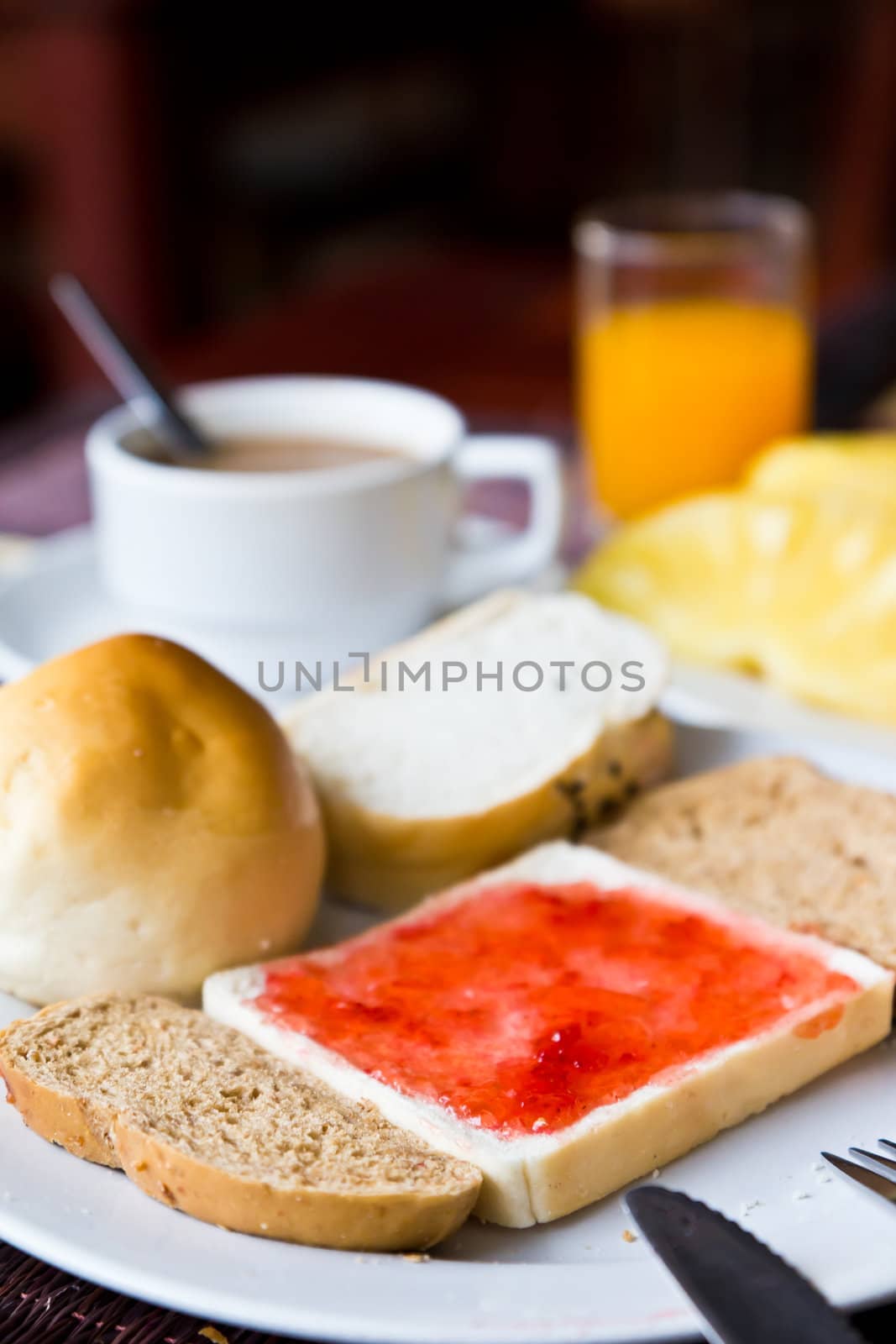 Coffee,bread, and juice in a dish on the dining table.