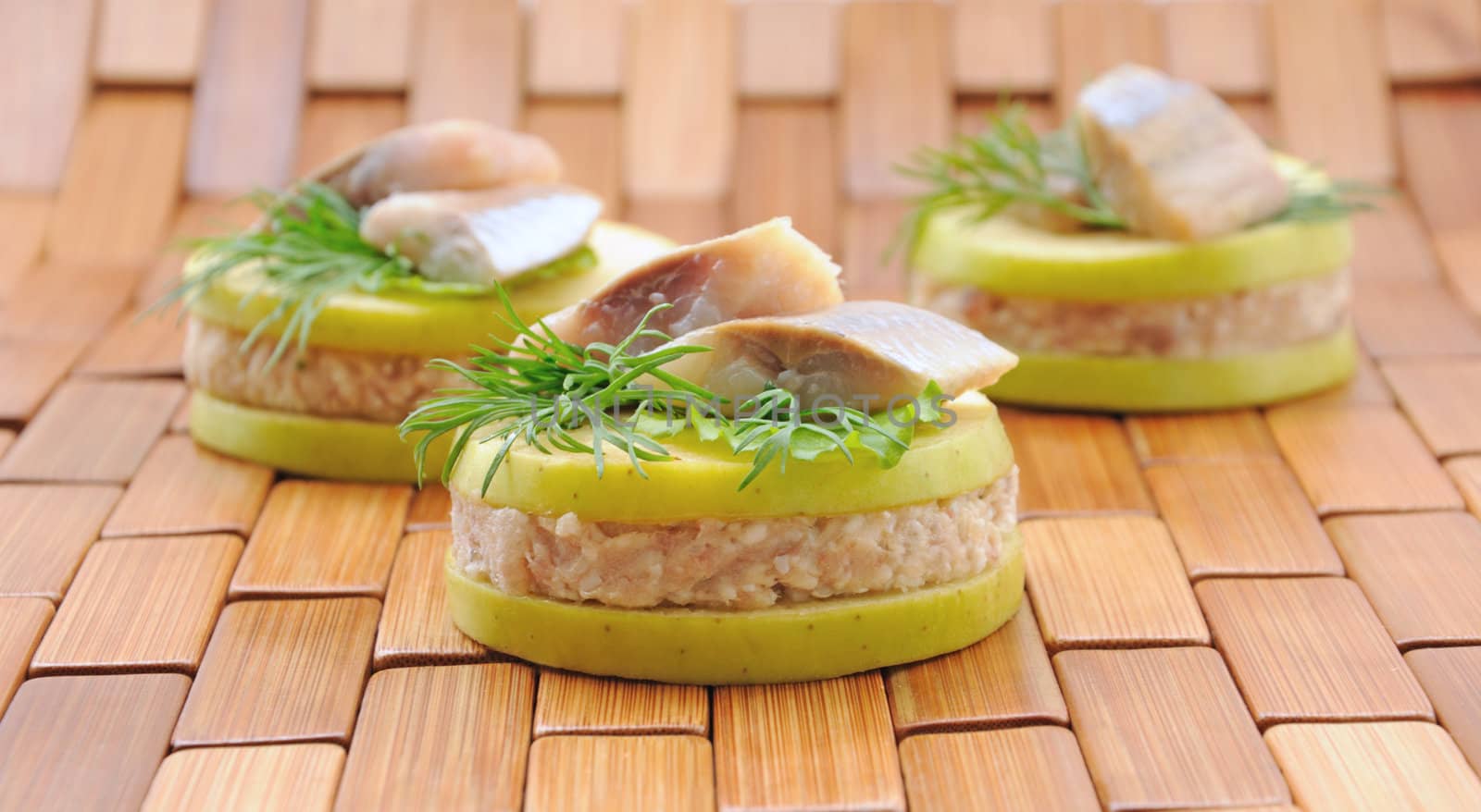 Appetizer of herring with apples with greens