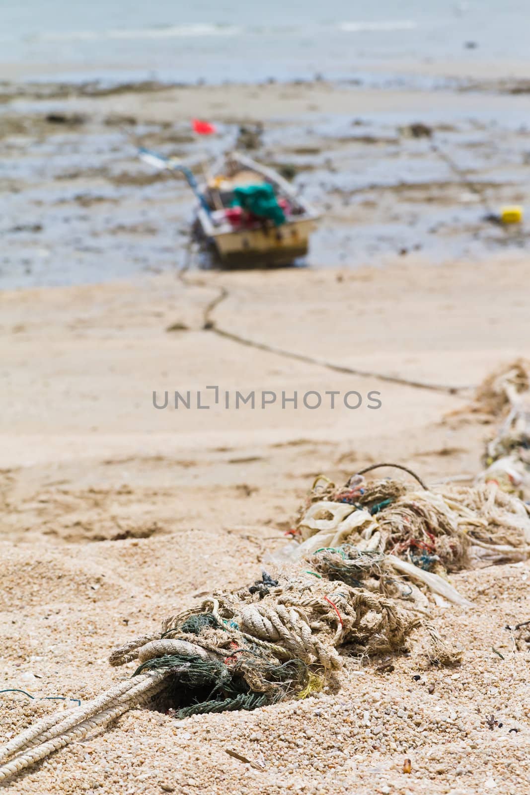 Rope tied to a fishing boat on the beach. by Na8011seeiN