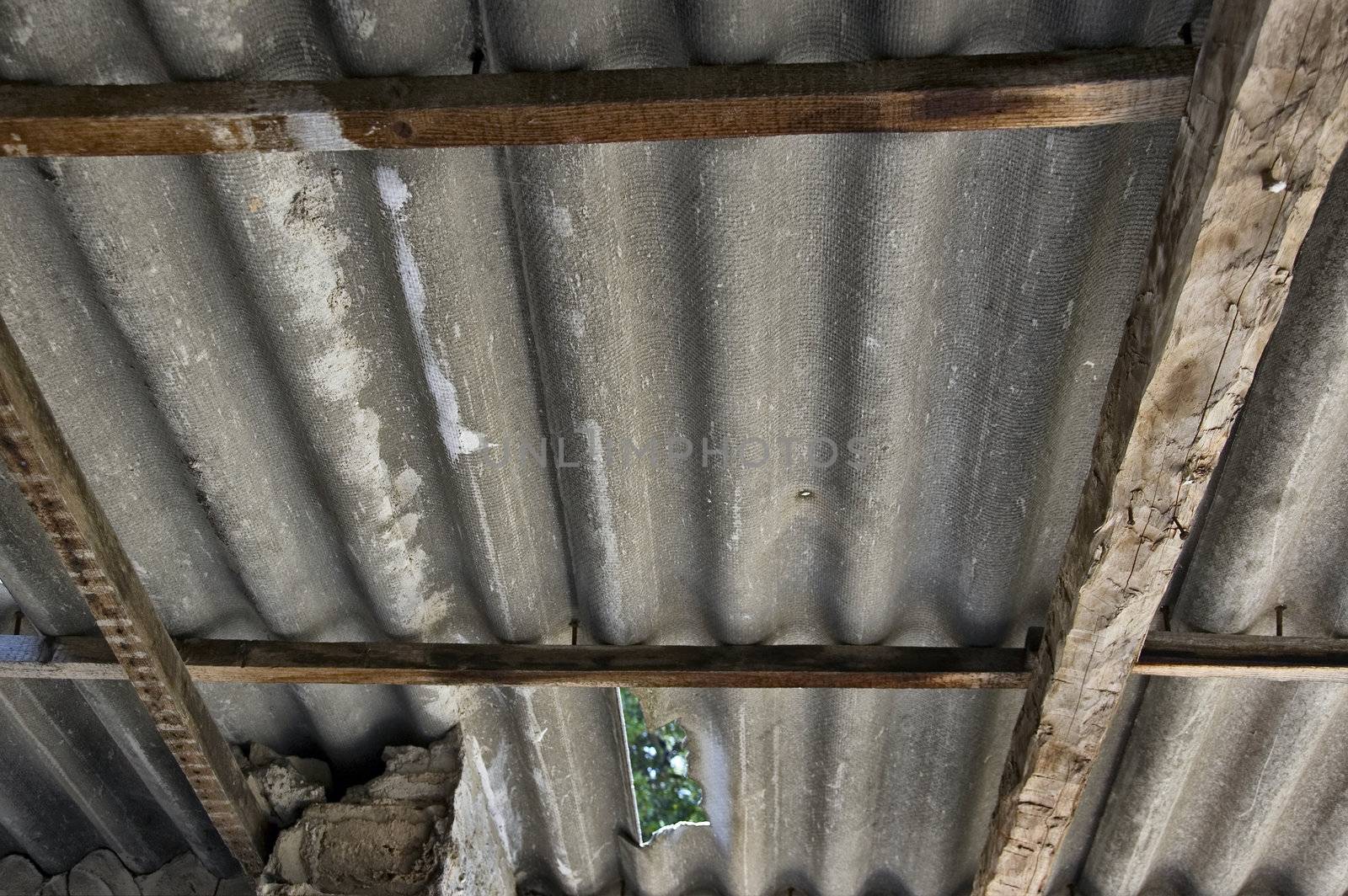 Broken absbestos roofing inside an abandoned house. Hazardous material.