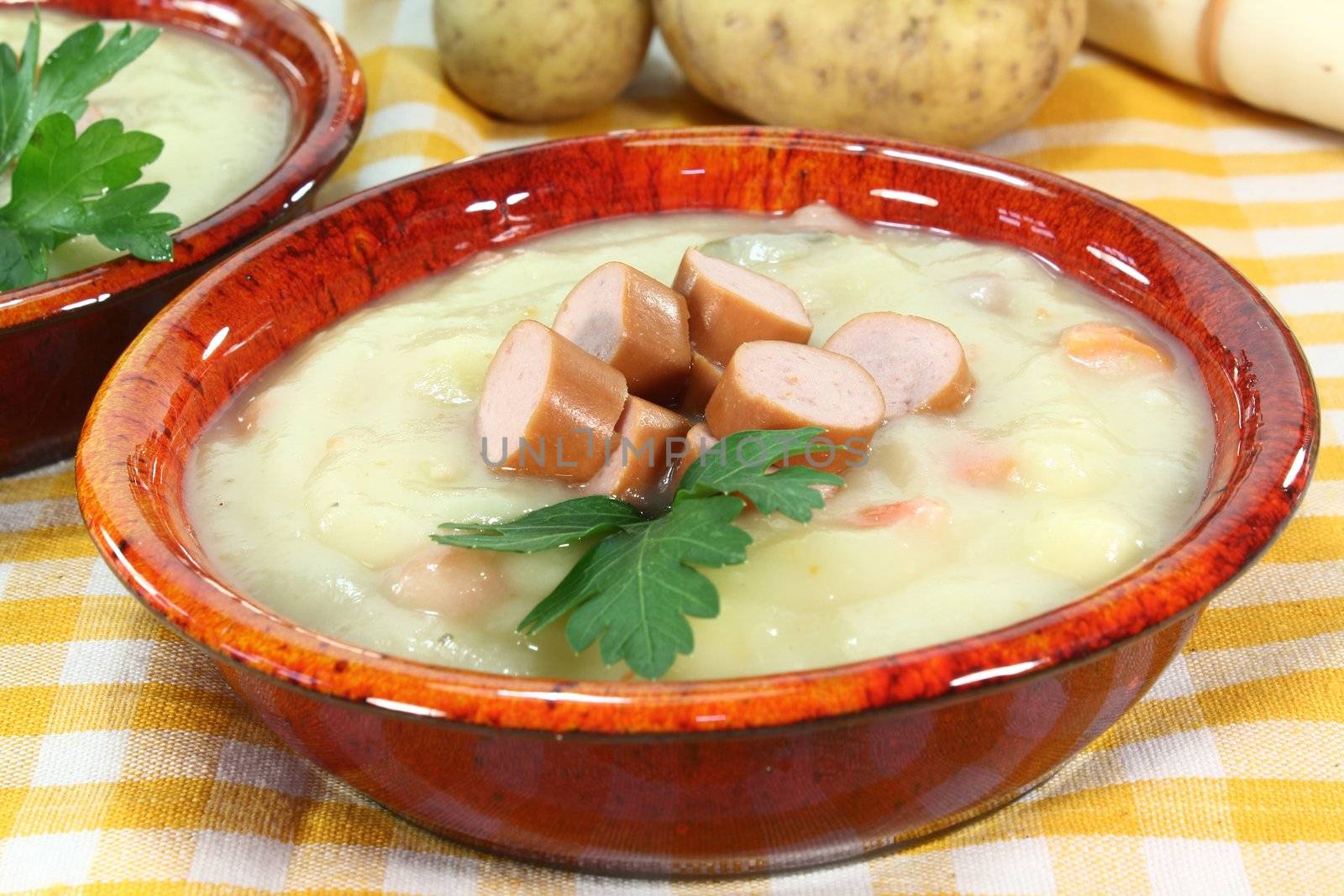 a red bowl of potato soup with parsley