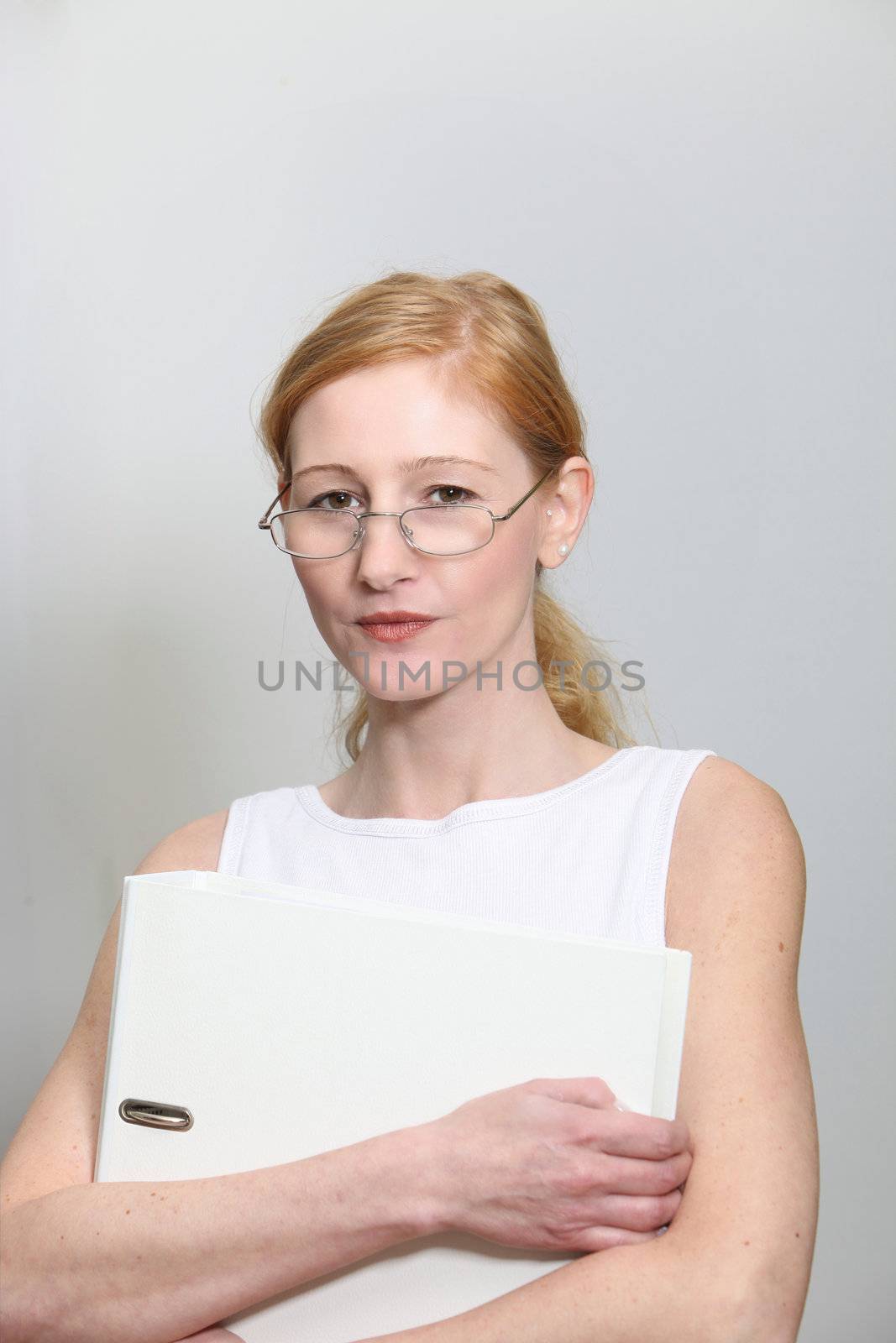 Determined young woman in the office. She holds a file folder