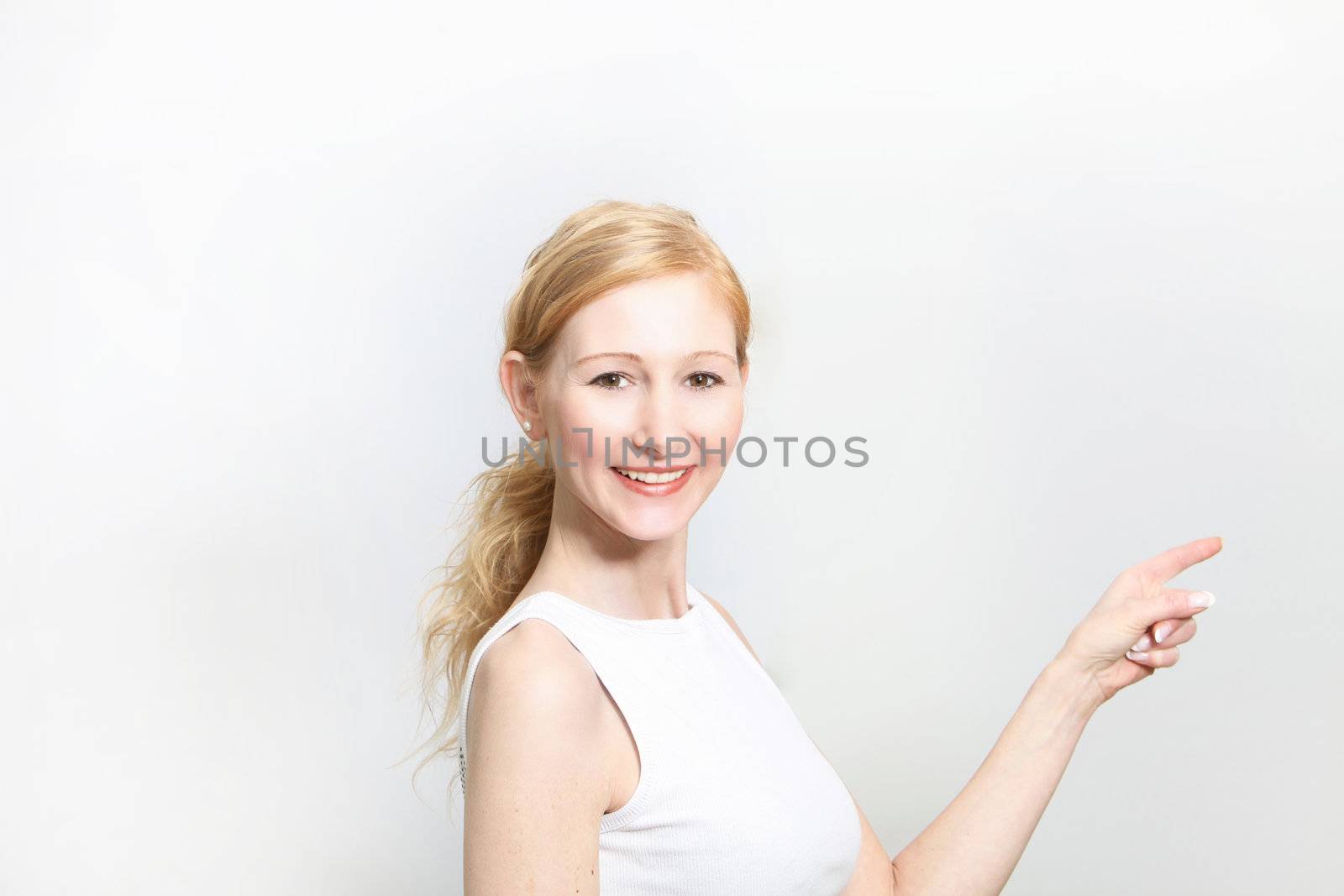 Young, pretty woman pointing at something - copy space - Horizontal