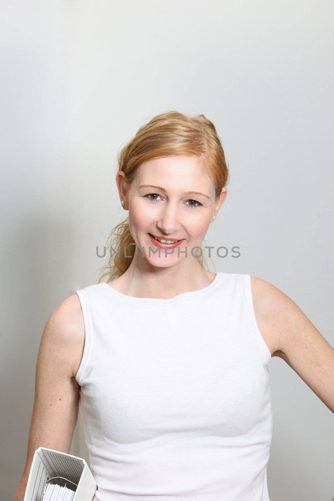 Young, pretty woman with folders in the office - portrait format
