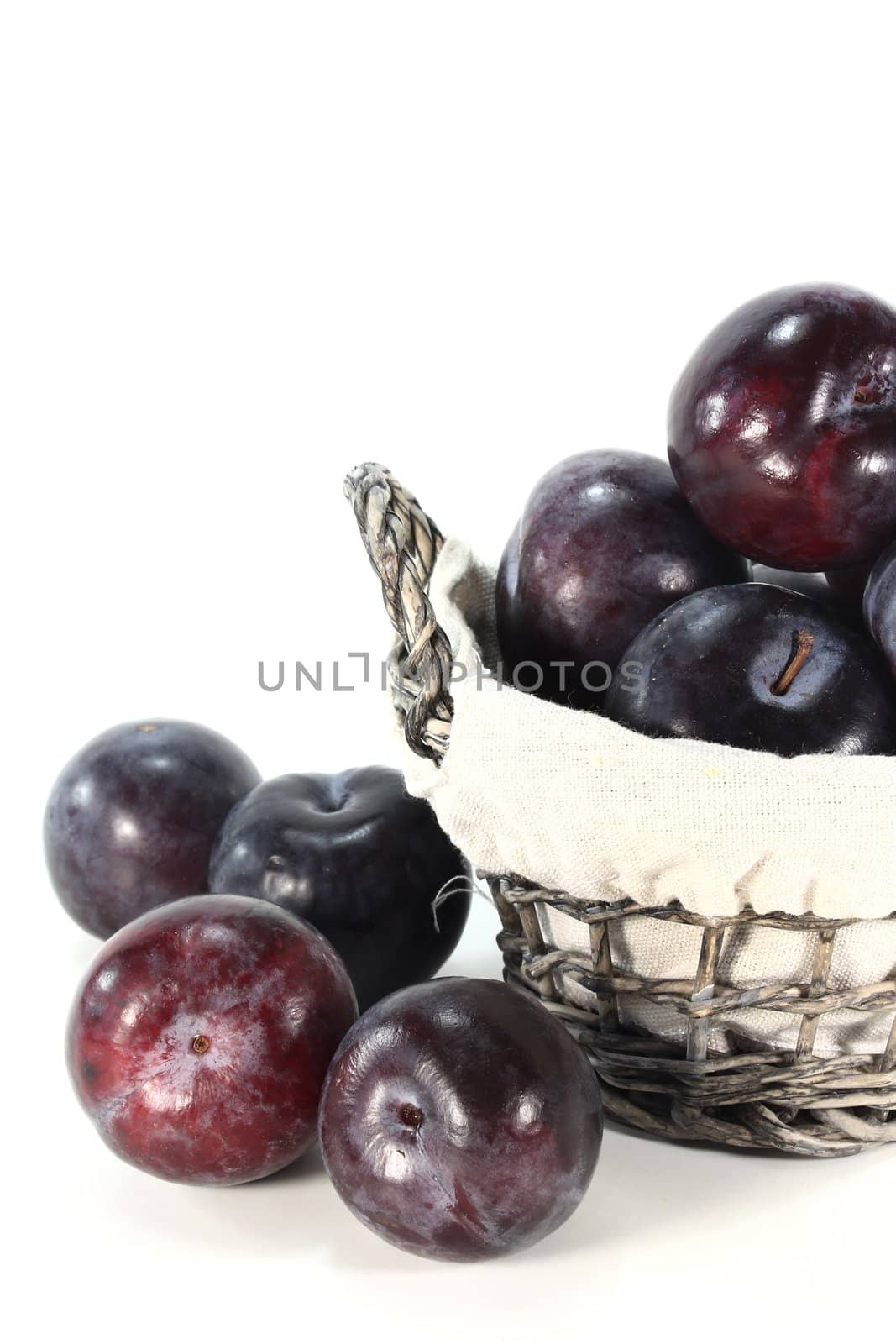 Fresh plums with leaves in a basket