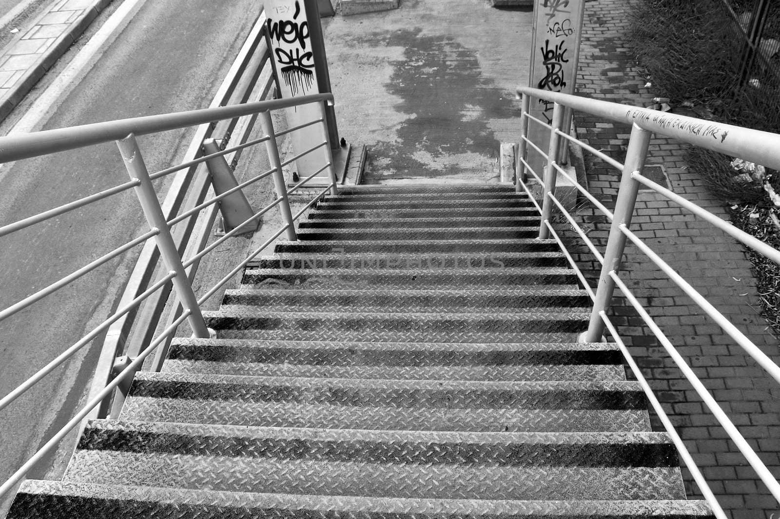 Metal stairs of pedestrian overpass bridge. Black and white.