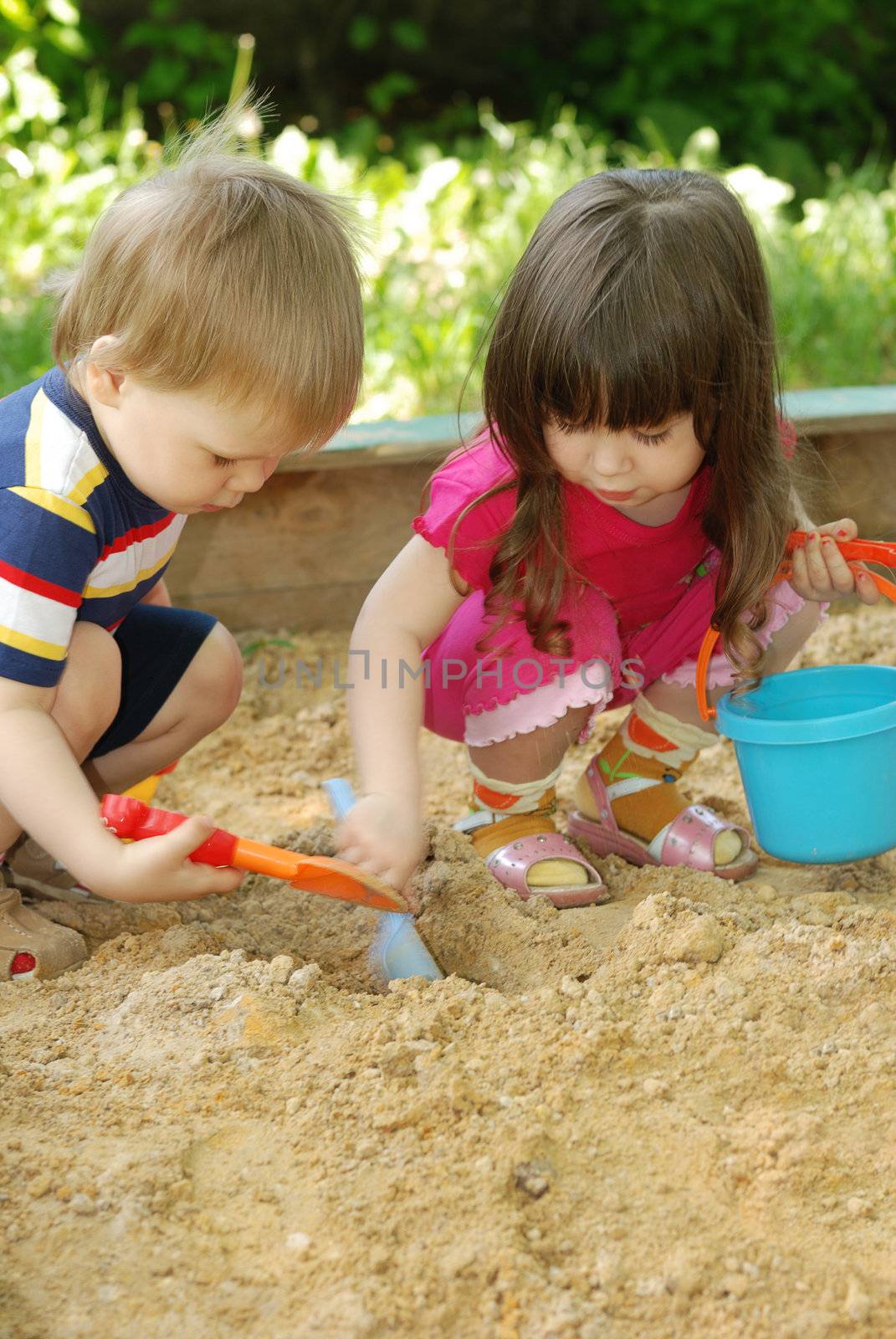 The boy and girl playing to a sandbox. Caucasian the child, park of rest