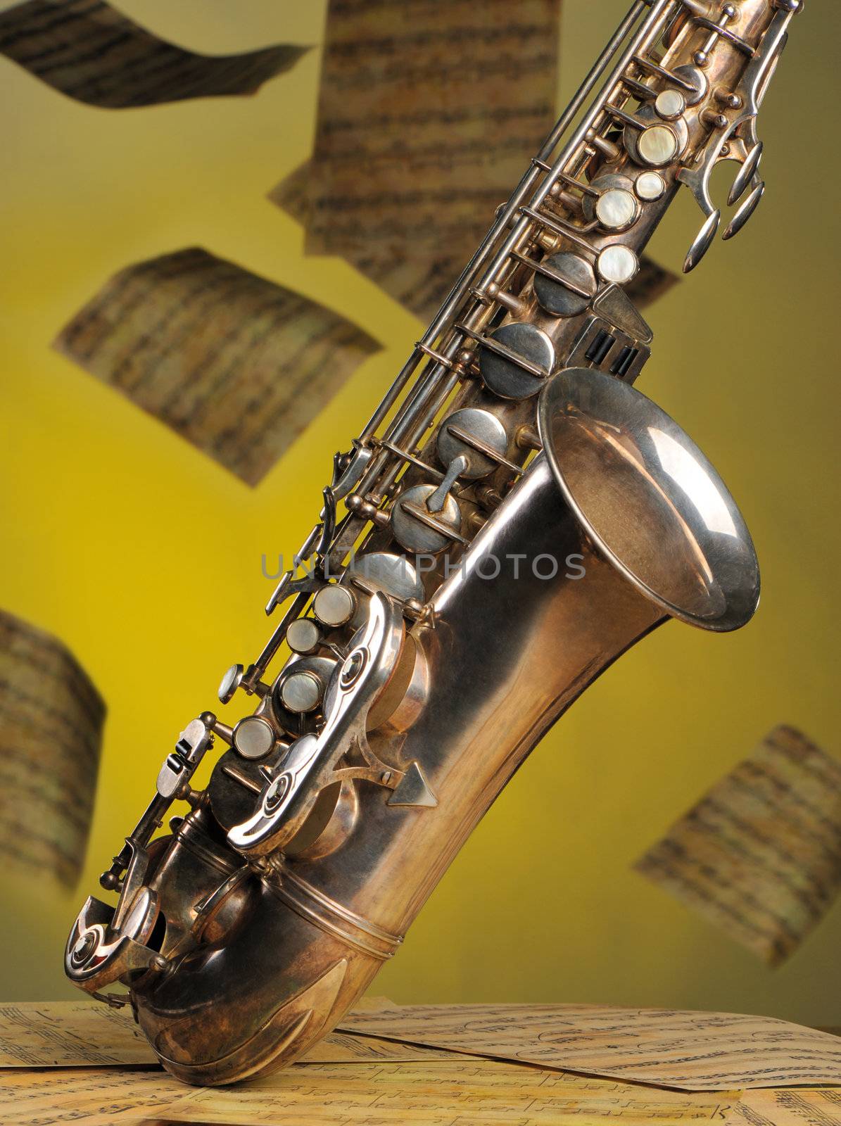 Old saxophone and flying musical notes on a background. The Musical instrument standing on notes with classical music of the beginning of 17 centuries