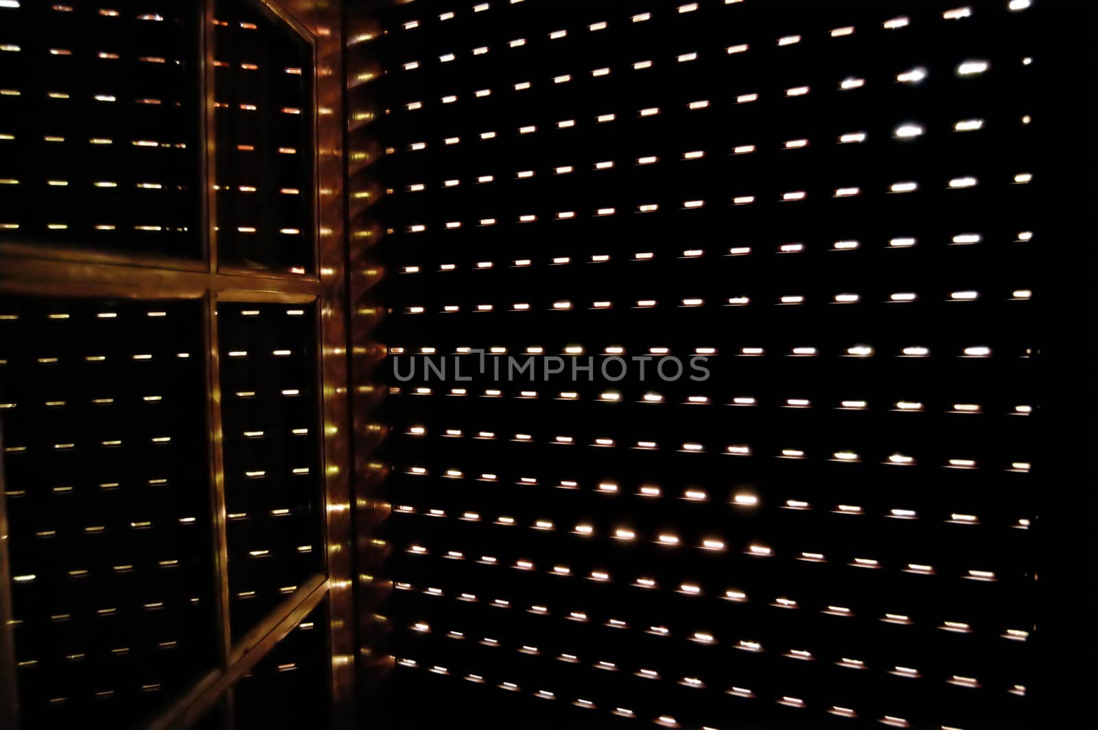 Light shining through a closed window shutter on a bright sunny day.