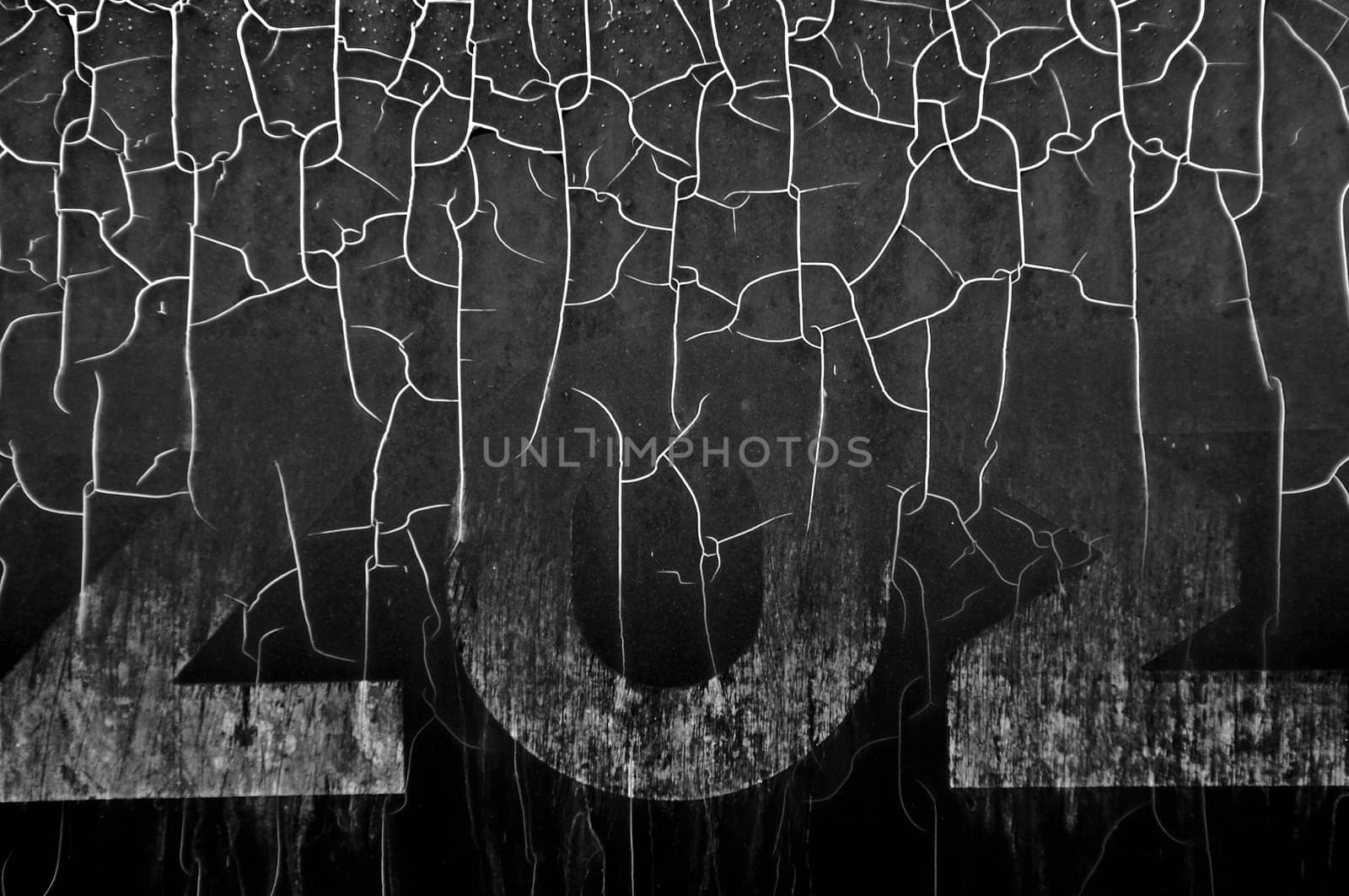 Cracked plastic surface with faded typography. Black and white.